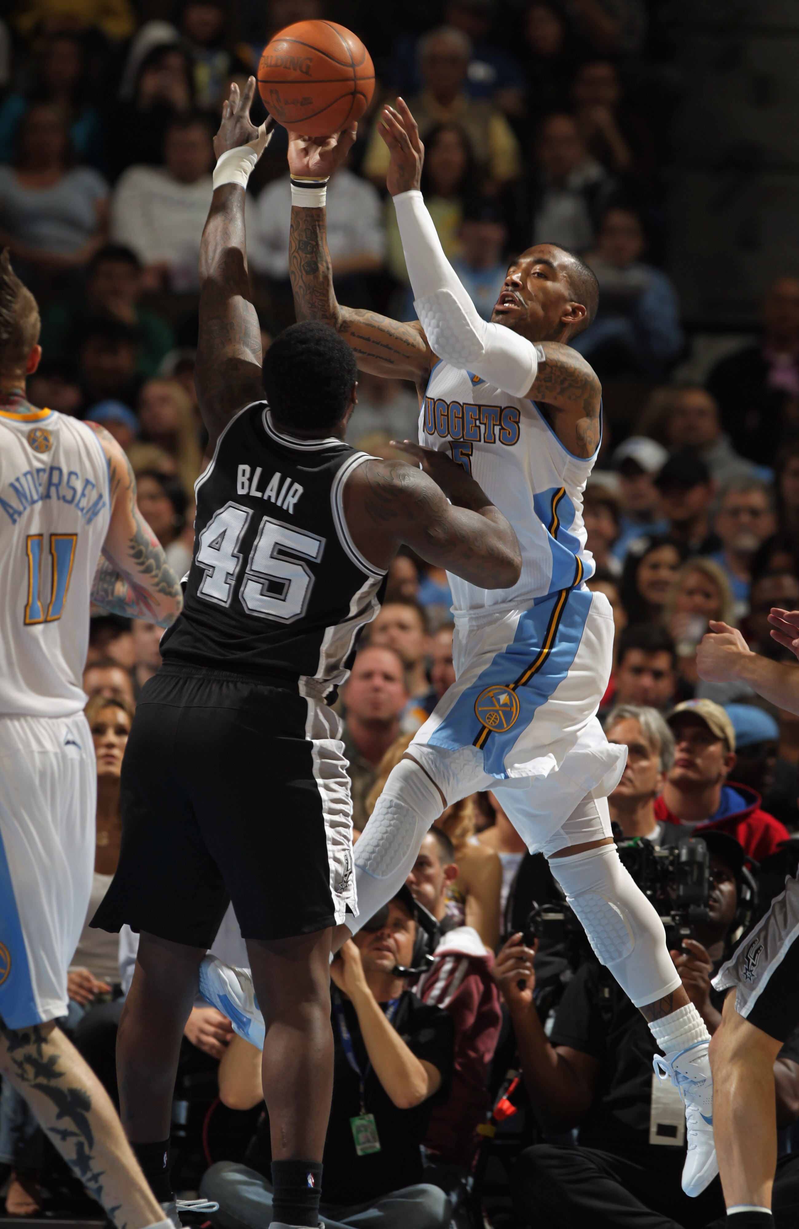 DENVER, CO - MARCH 23:  J.R. Smith #5 of the Denver Nuggets passes the ball against the defense of DeJuan Blair #45 of the San Antonio Spurs at the Pepsi Center on March 23, 2011 in Denver, Colorado. The Nuggets defeated the Spurs 115-112. NOTE TO USER: U