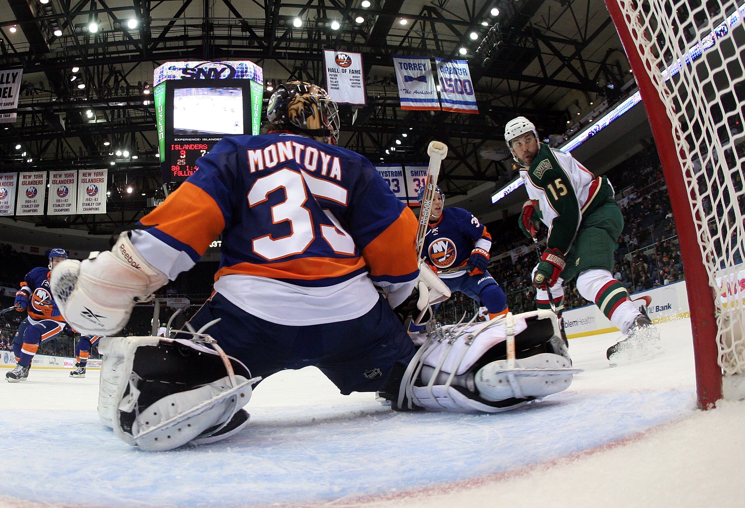 UNIONDALE, NY - MARCH 02:  Al Montoya #35 of the New York Islanders makes the save as Andrew Brunette #15 of the Minnesota Wild looks for a rebound at the Nassau Coliseum on March 2, 2011 in Uniondale, New York.  (Photo by Bruce Bennett/Getty Images)