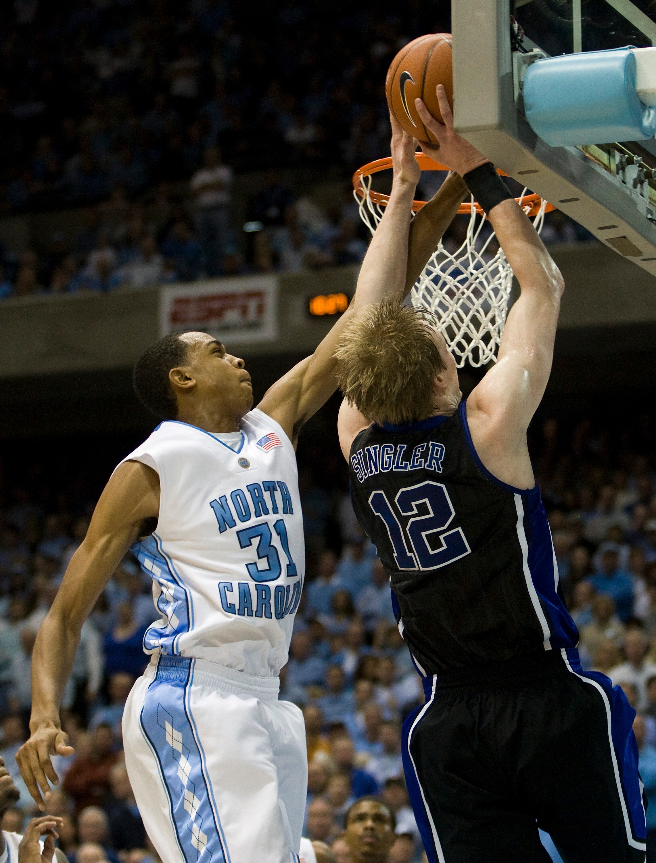 CHAPEL HILL, NC - FEBRUARY 10: Duke forward Kyle Singler #12 works to shoot the ball against North Carolina forward John Henson #31 during a men's college basketball game at Dean Smith Center on February 10, 2010 in Chapel Hill, North Carolina. (Photo by