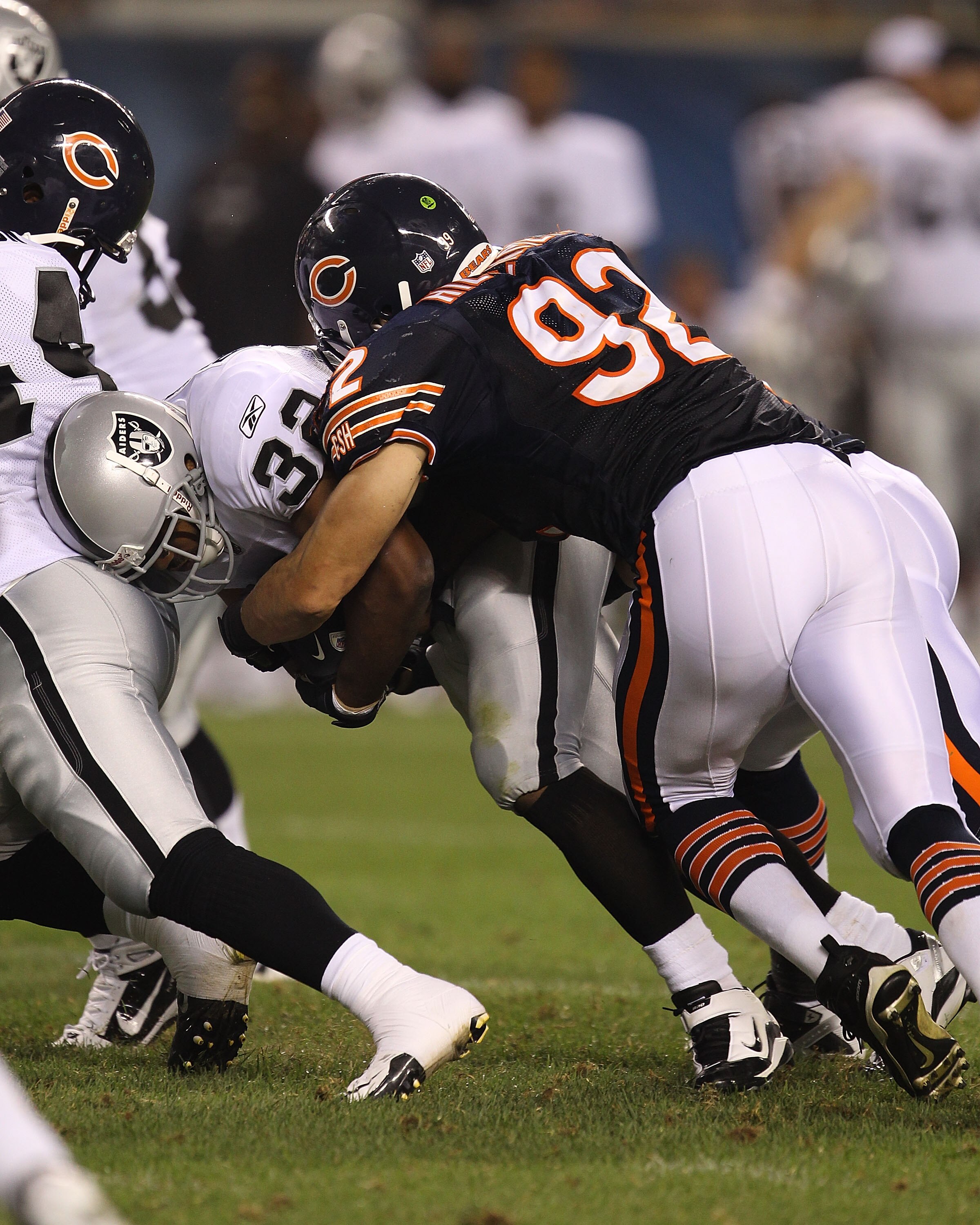 CHICAGO - AUGUST 21: Hunter Hillenmeyer #92 of the Chicago Bears tackles Michael Bennett #32 of the Oakland Raiders during a preseason game at Soldier Field on August 21, 2010 in Chicago, Illinois. The Raiders defeated the Bears 32-17. (Photo by Jonathan 