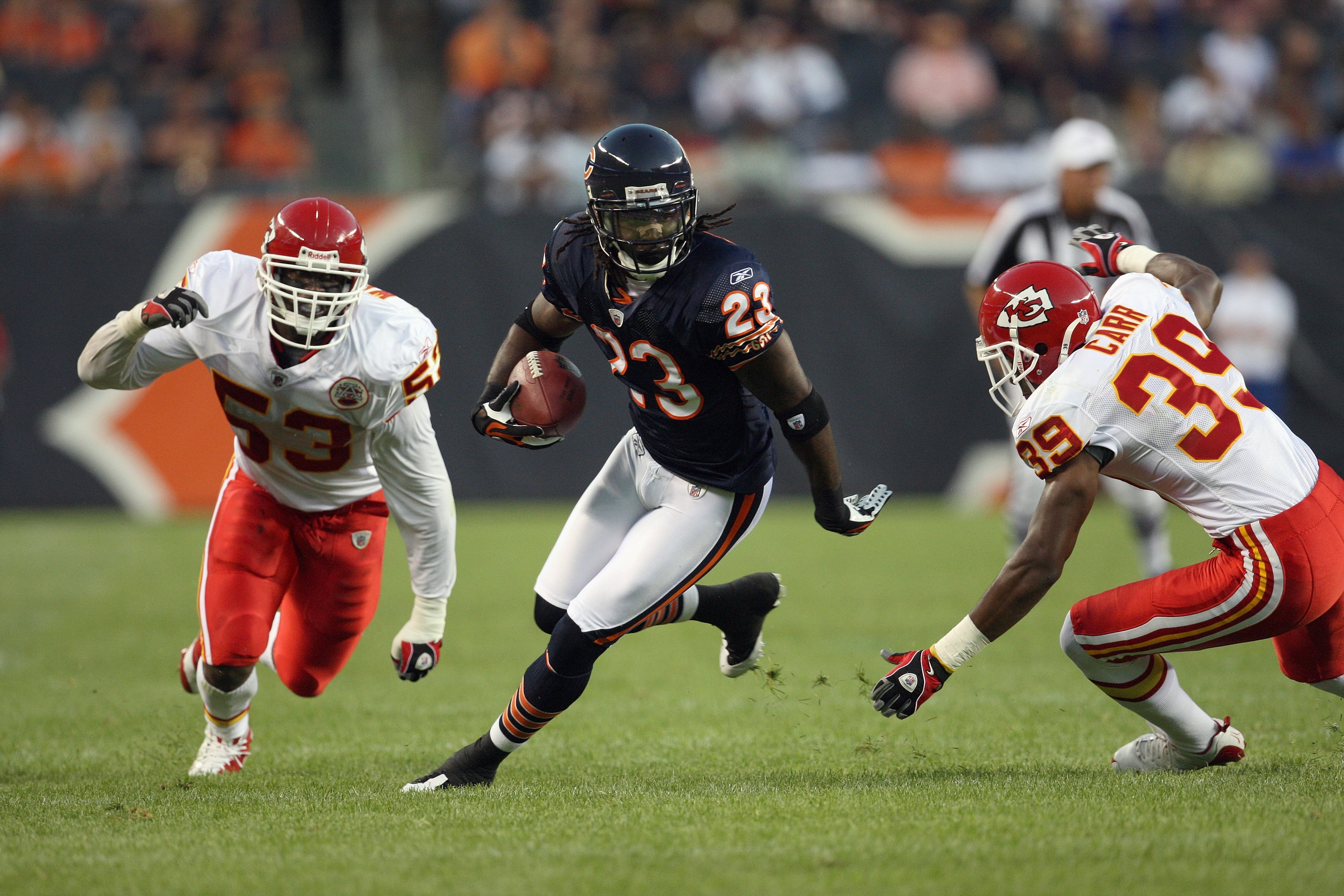 CHICAGO - AUGUST 7:  Devin Hester #23 of the Chicago Bears carries the ball against Demorrio Williams #53 and Brandon Carr #39 of the Kansas City Chiefs during a preseason game on August 7, 2008 at Soldier Field in Chicago, Illinois. (Photo by Jonathan Da