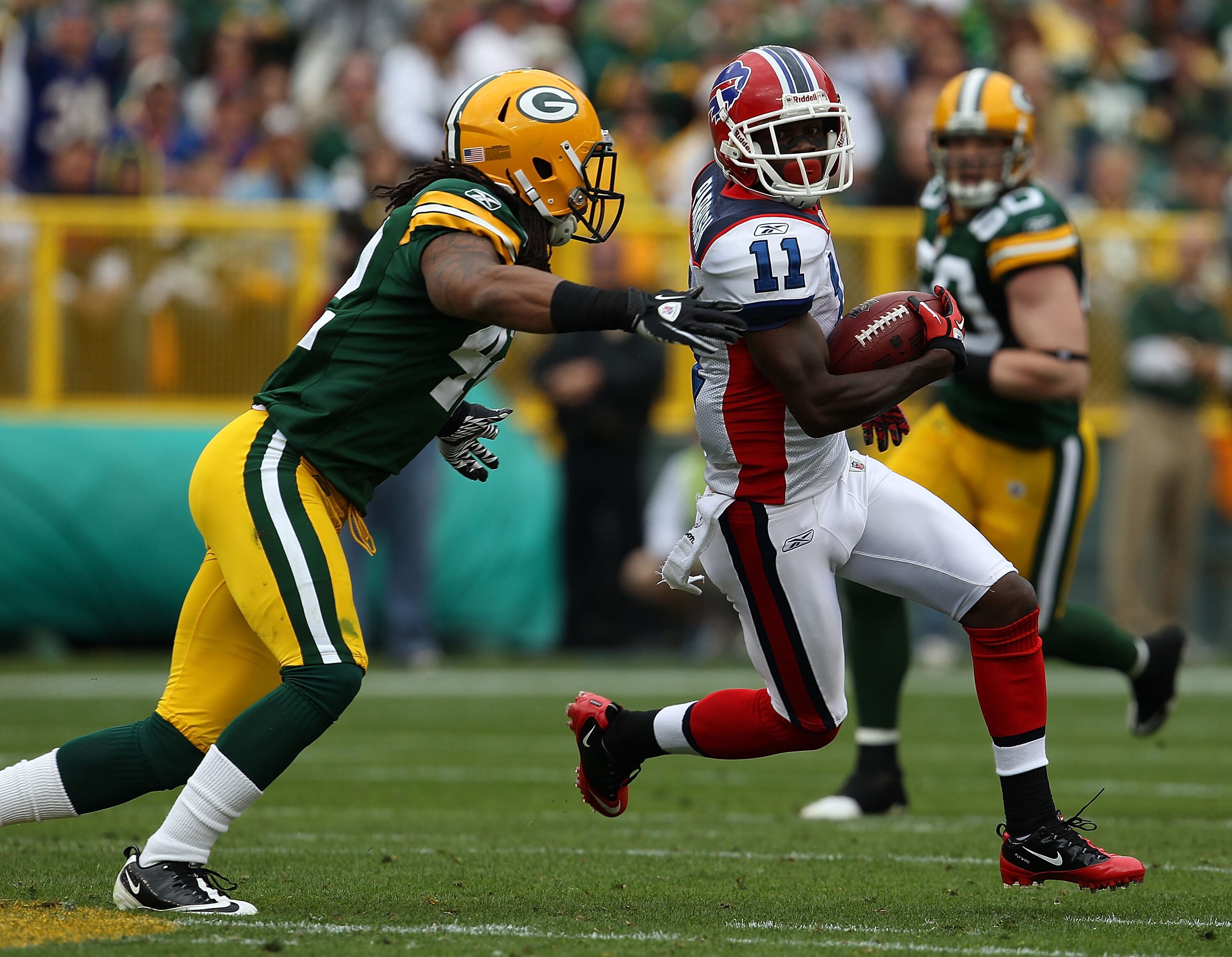 GREEN BAY, WI - SEPTEMBER 19: Roscoe Parrish #11 of the Buffalo Bills tries to avoid Morgan Burnett #42 of the Green Bay Packers after catching a pass at Lambeau Field on September 19, 2010 in Green Bay, Wisconsin. The Packers defeated the Bills 34-7. (Ph