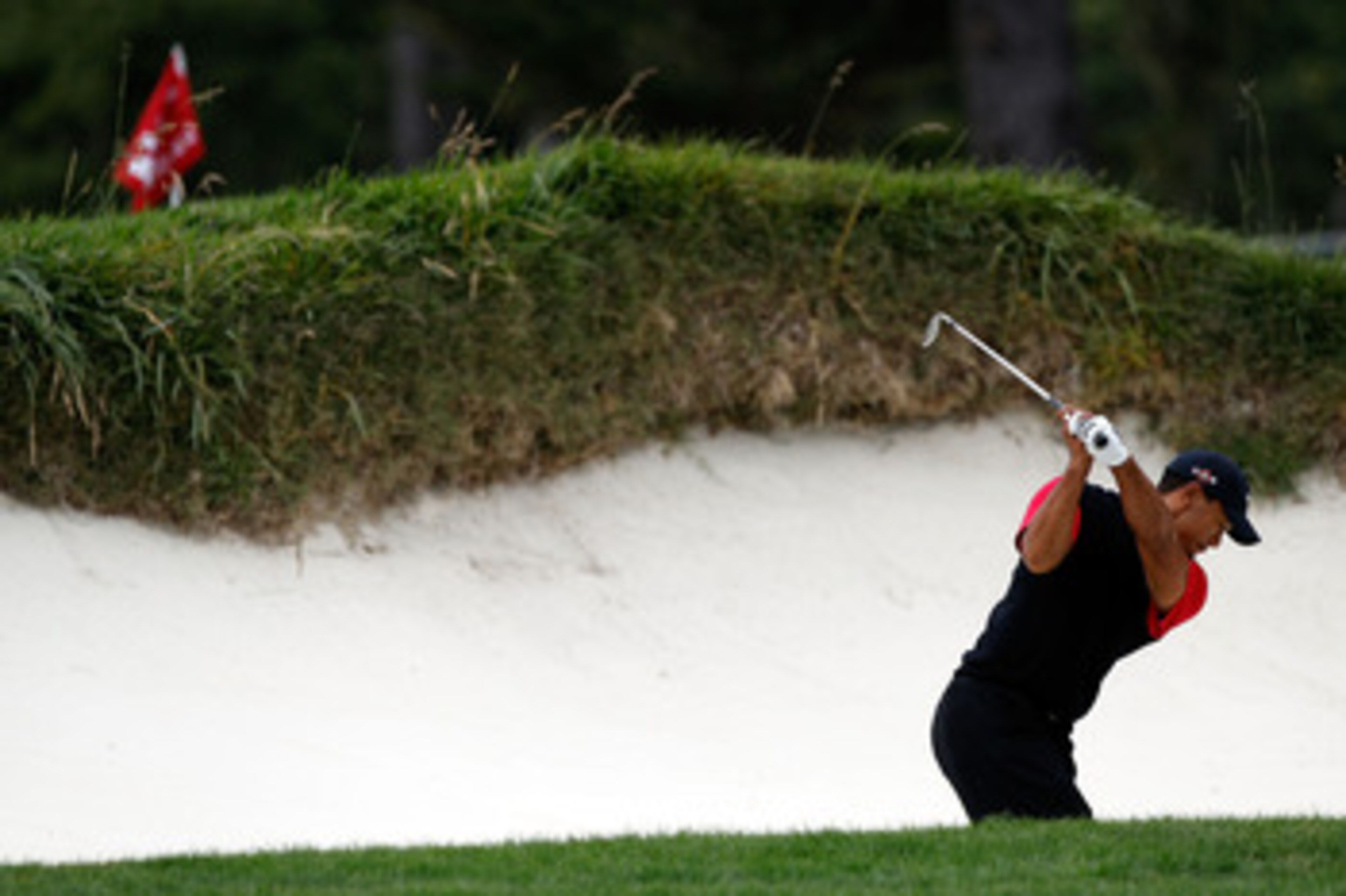 PEBBLE BEACH, CA - JUNE 20:  Tiger Woods plays from a greenside bunker on the 14th hole during the final round of the 110th U.S. Open at Pebble Beach Golf Links on June 20, 2010 in Pebble Beach, California.  (Photo by Donald Miralle/Getty Images)