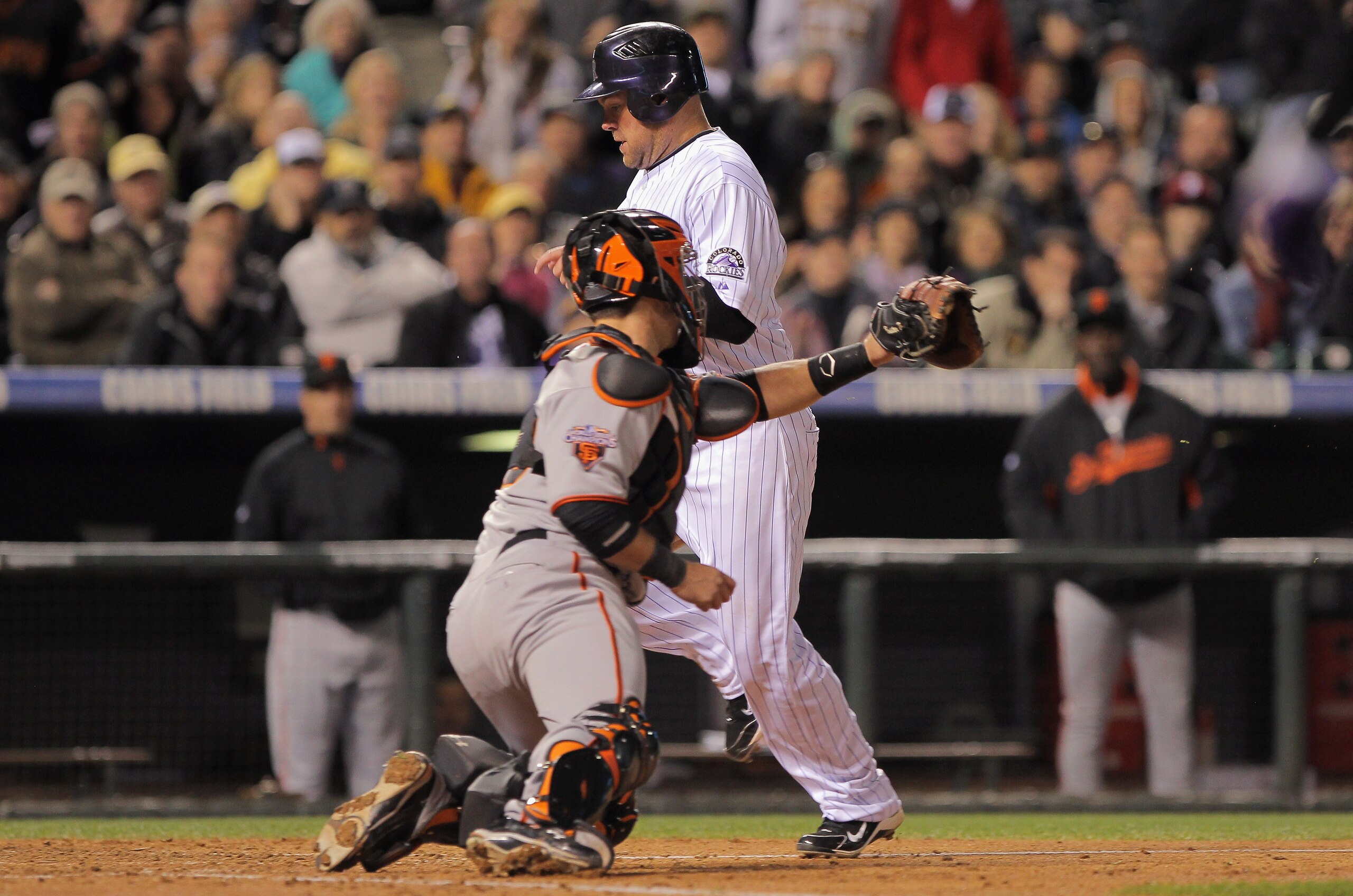 DENVER, CO - APRIL 19:  Ty Wigginton #21 of the Colorado Rockies scores as catcher Buster Posey #28 of the San Francisco Giants takes the late throw from rightfielder Pat Burrell #5 of the San Francisco Giants on a sacrifice fly by Seth Smith #7 of the Co