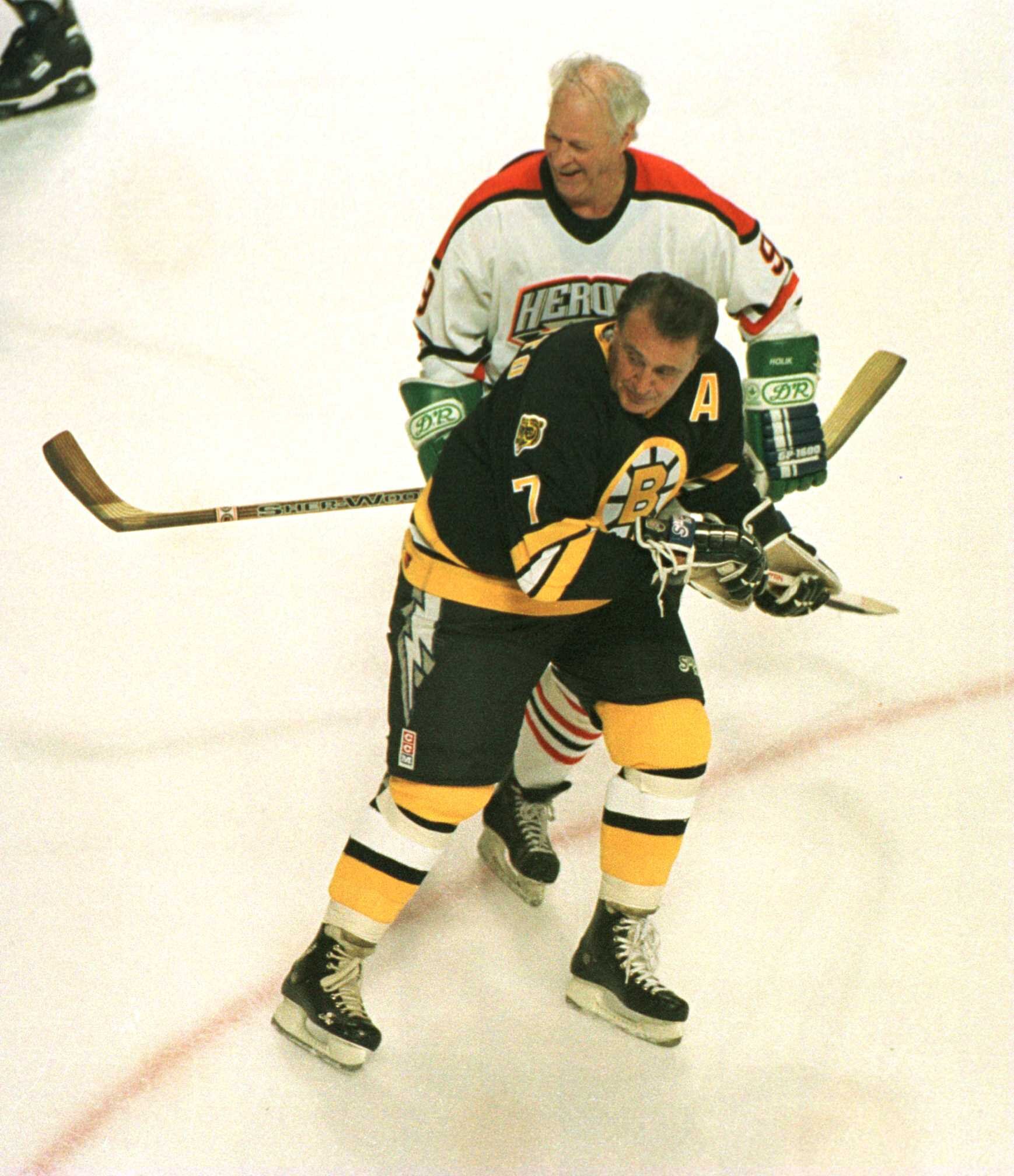 19 Jan 1996:  Wielding a double bladed stick, Gordie Howe #9 of the NHL Heroes checks Phil Esposito #7 of the Boston Bruins Heroes from behind during the second period of the NHL Heroes of Hockey game played at the Fleet Center in Boston, Massachusetts. M