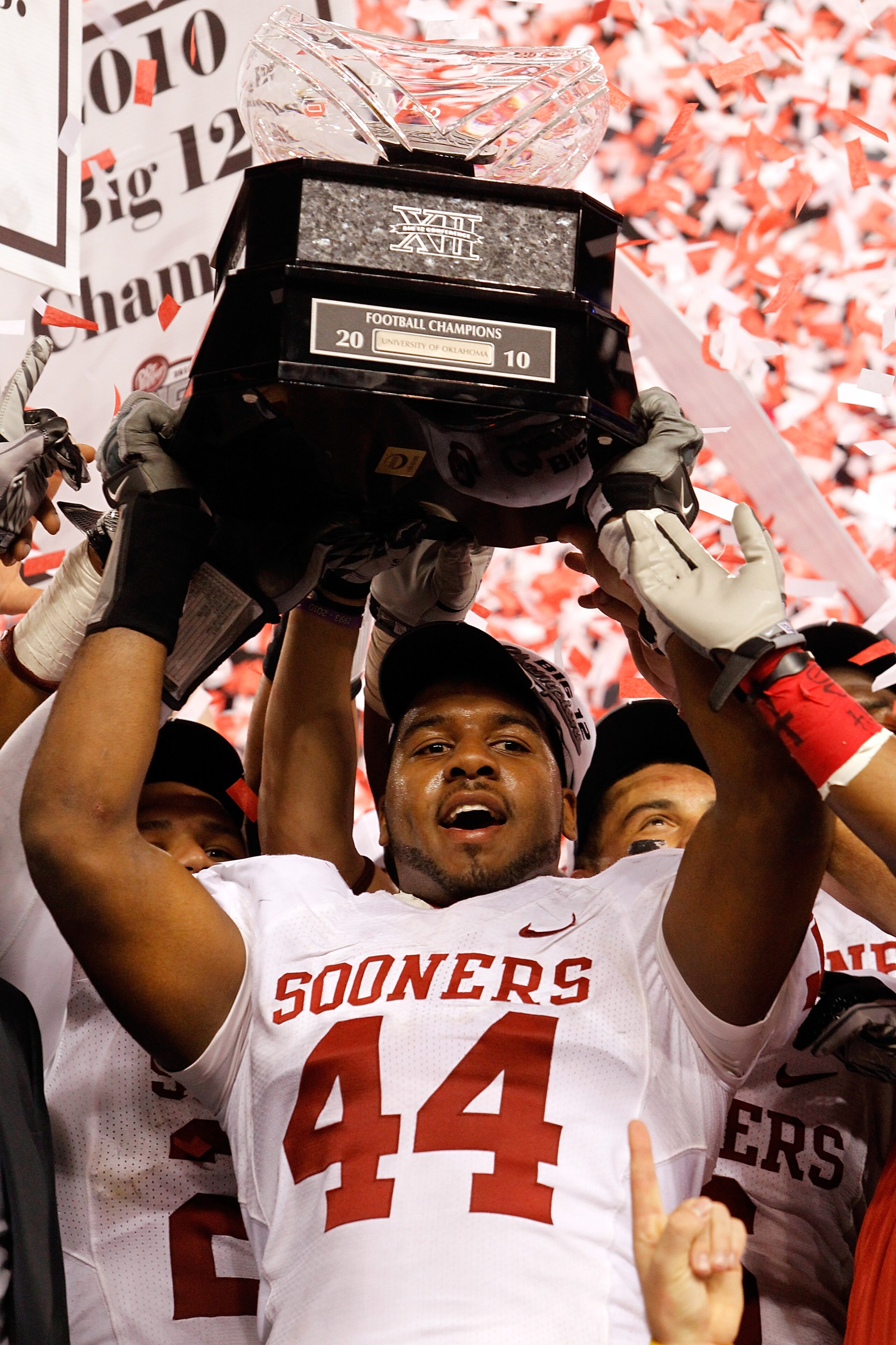 ARLINGTON, TX - DECEMBER 04:  Defensive end Jeremy Beal #44 of the Oklahoma Sooners celebrates with the Big 12 Championship Trophy after the Sooners beat the Nebraska Cornhuskers 23-20 at Cowboys Stadium on December 4, 2010 in Arlington, Texas.  (Photo by