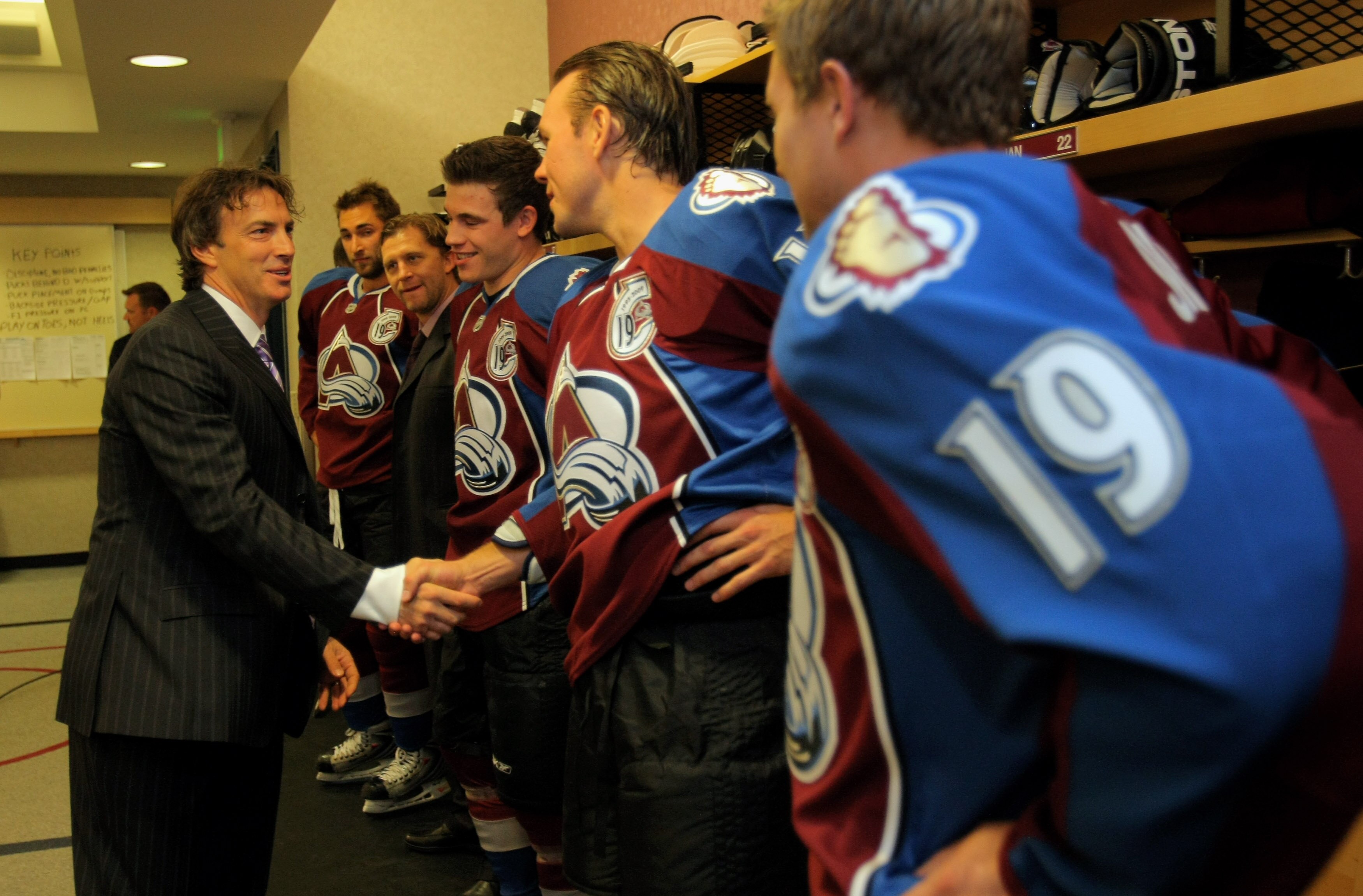 DENVER - OCTOBER 01:  Joe Sakic shakes the hand of Scott Hannan as he greets all the players of the Colorado Avalanche in the locker room on the night when Sakic's jersey was retired at the Pepsi Center on October 1, 2009 in Denver, Colorado.  (Photo by D