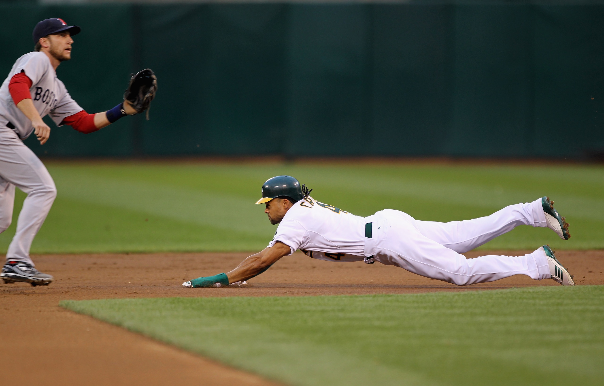 OAKLAND, CA - APRIL 19: Coco Crisp #4 of the Oakland Athletics steals second base in front on Jed Lowrie #12 of the Boston Red Sox during the first inning at Oakland-Alameda County Coliseum on April 19, 2011 in Oakland, California. Crisp scored later in OAKLAND, CA - APRIL 19: Coco Crisp #4 of the Oakland Athletics steals second base in front on Jed Lowrie #12 of the Boston Red Sox during the first inning at Oakland-Alameda County Coliseum on April 19, 2011 in Oakland, California. Crisp scored later in