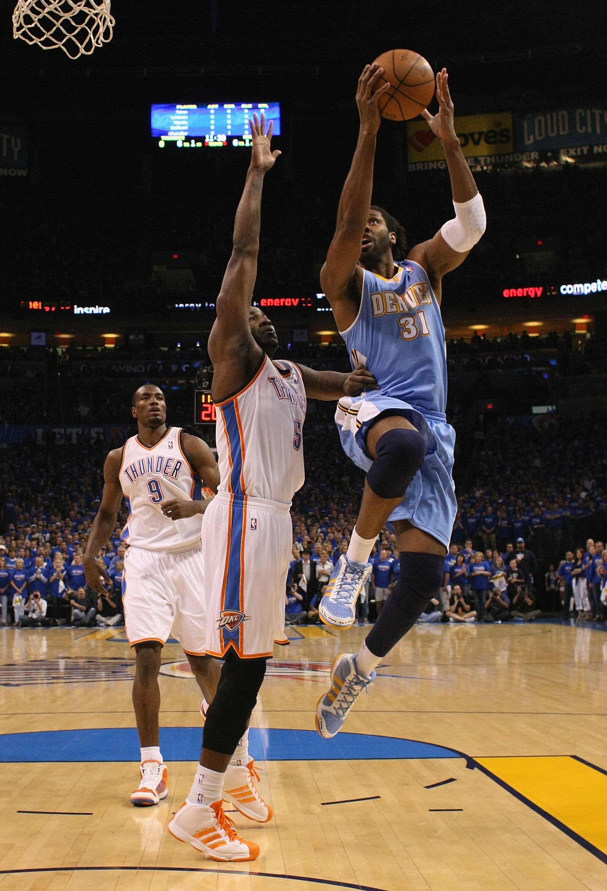 OKLAHOMA CITY, OK - APRIL 17: Nene #31 of the Denver Nuggets drives to the basket against Kendrick Perkins #5 of the Oklahoma City Thunder in Game One of the Western Conference Quarterfinals in the 2011 NBA Playoffs on April 17, 2011 at the Ford Center in OKLAHOMA CITY, OK - APRIL 17: Nene #31 of the Denver Nuggets drives to the basket against Kendrick Perkins #5 of the Oklahoma City Thunder in Game One of the Western Conference Quarterfinals in the 2011 NBA Playoffs on April 17, 2011 at the Ford Center in