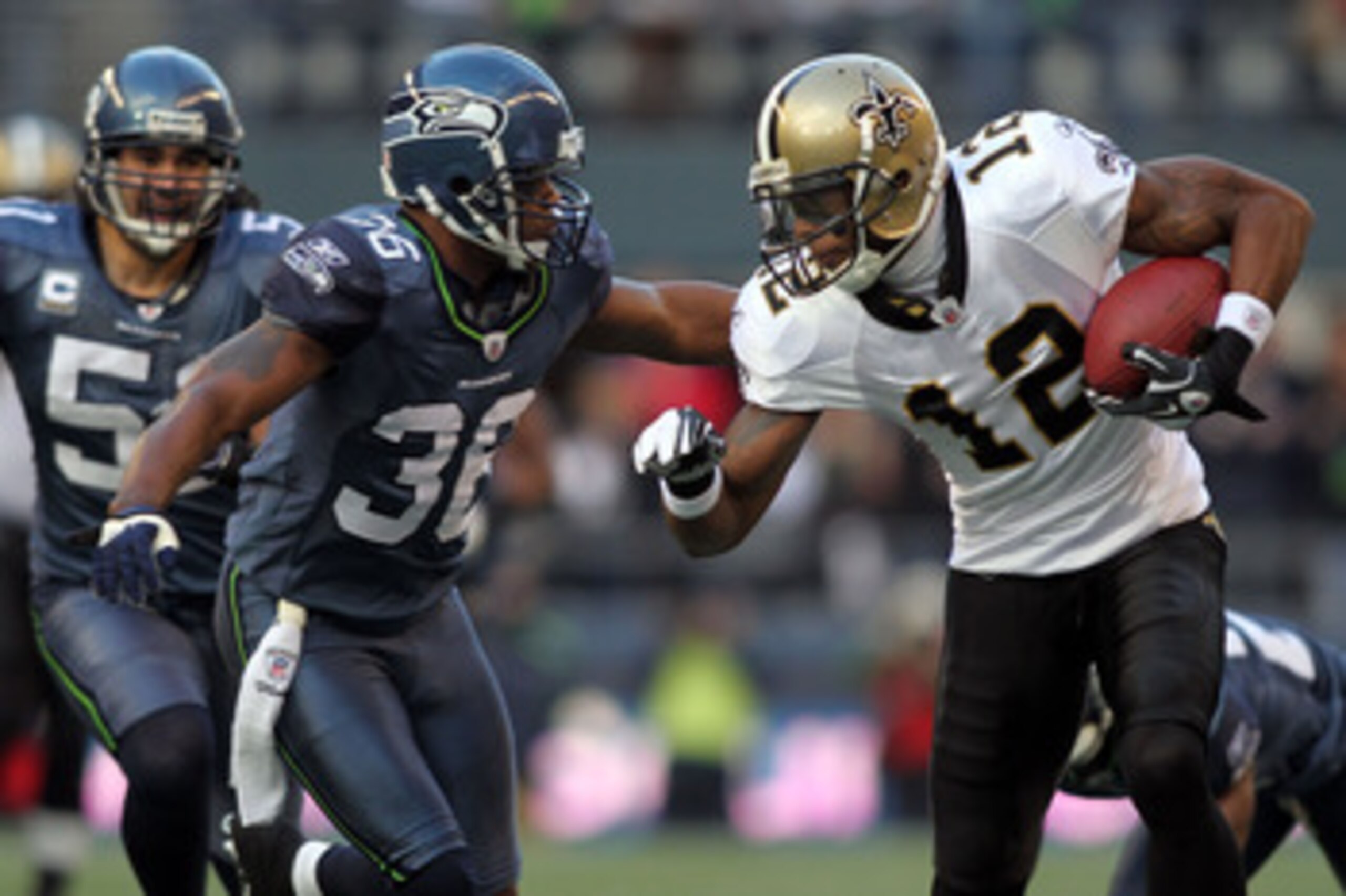 SEATTLE, WA - JANUARY 08:  Marques Colston #12 of the New Orleans Saints attempts to avoid a tackle from Lawyer Milloy #36 of the Seattle Seahawks as Colston runs for 30-yards after a catch in the first quarter during the 2011 NFC wild-card playoff game a
