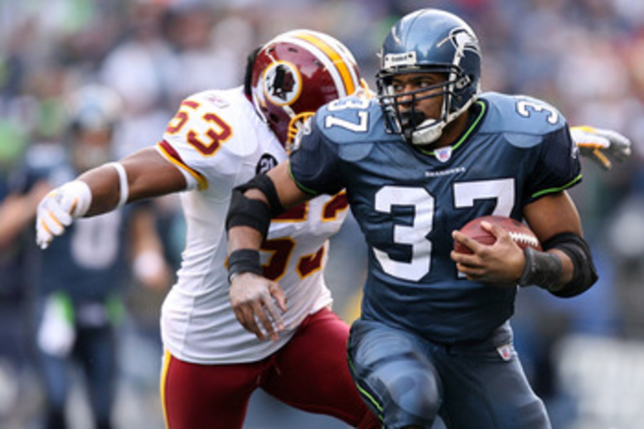 SEATTLE - JANUARY 05:  Running back Shaun Alexander #37 of the Seattle Seahawks runs for 17-yards as linebacker Marcus Washinton #53 of the Washington Redskins tries to tackle Alexander in the first quarter of the NFC Wild Card game at Qwest Field on Janu