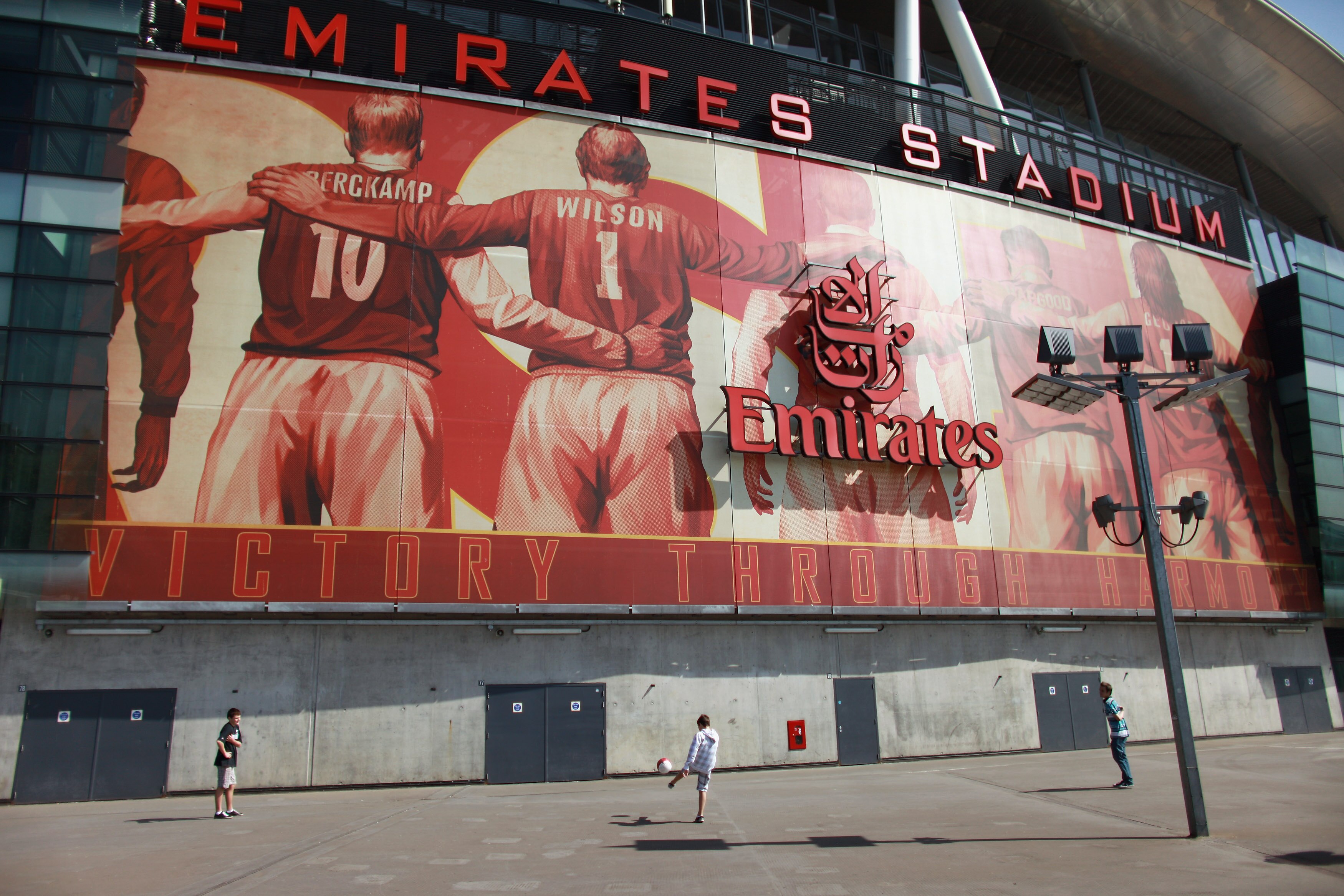 LONDON, ENGLAND - APRIL 11:  Boys play football in front of Arsenal Football Club's Emirates Stadium on April 11, 2011 in London, England. American businessman Stan Kroenke's company 'Kroenke Sports Enterprises' has increased its shareholding in Arsenal t