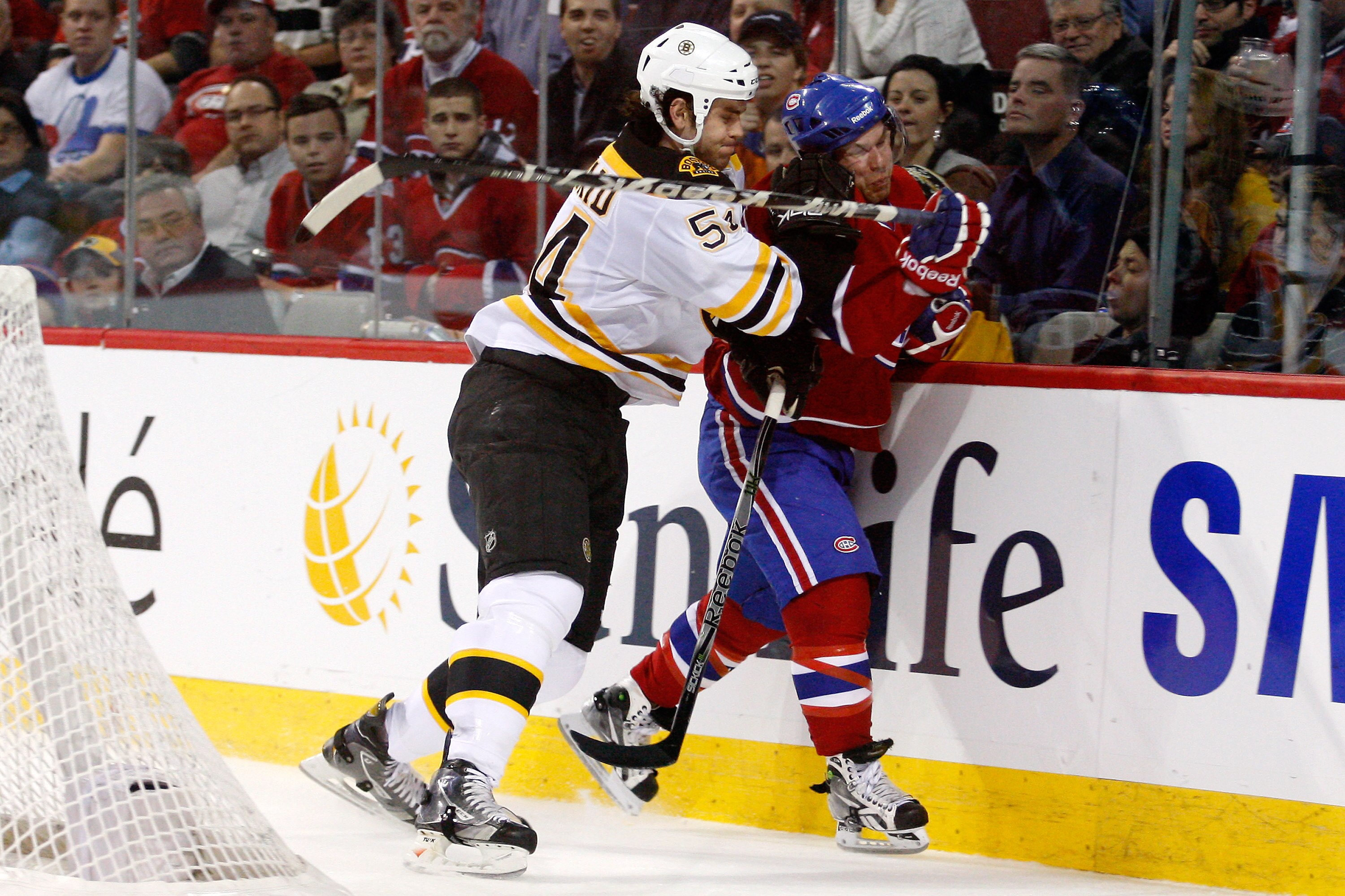 MONTREAL, CANADA - JANUARY 8:  Adam McQuaid #54 of the Boston Bruins body checks David Desharnais #58 of the Montreal Canadiens during the NHL game at the Bell Centre on January 8, 2011 in Montreal, Quebec, Canada.  The Canadiens defeated the Bruins 3-2 i