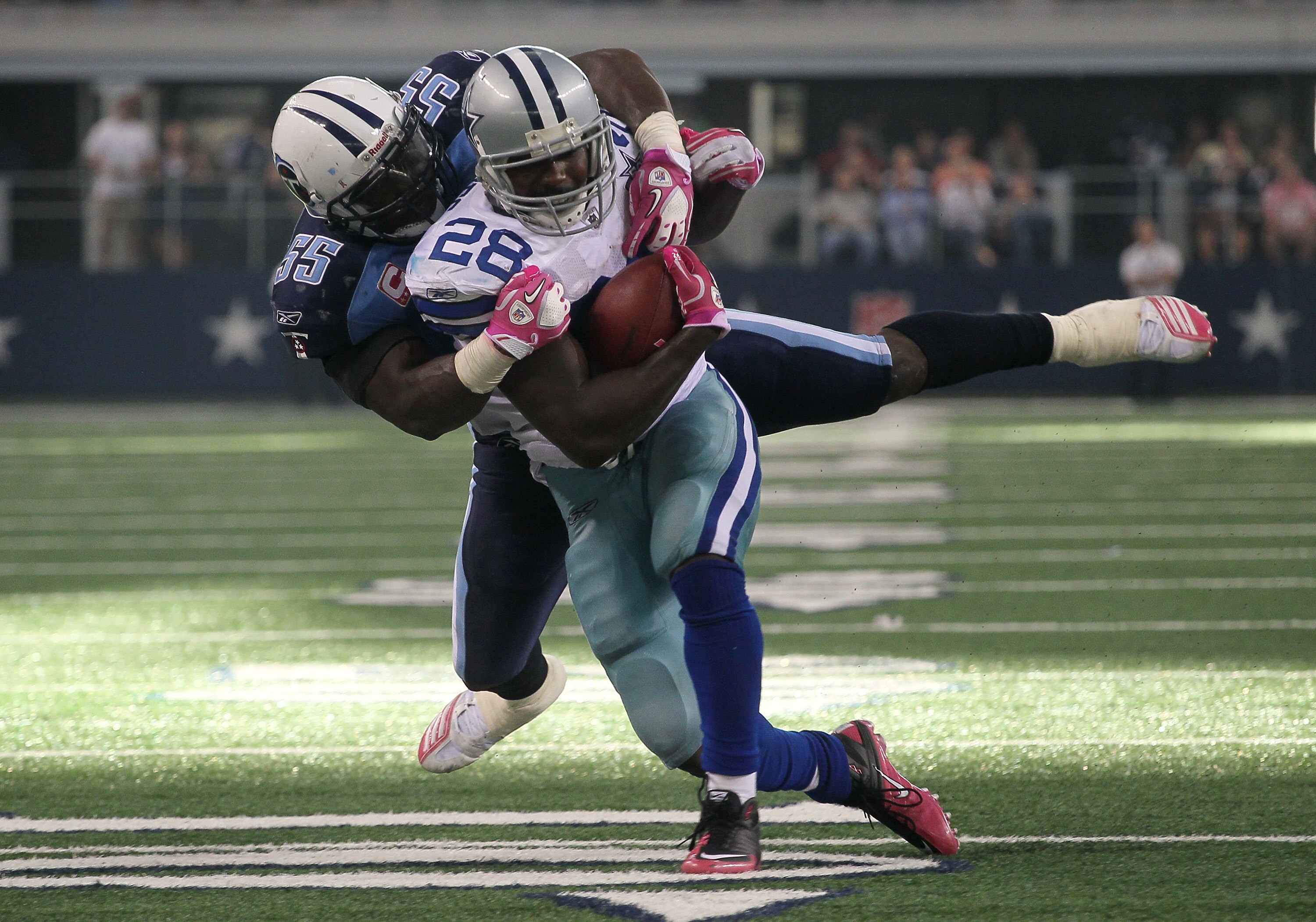 ARLINGTON, TX - OCTOBER 10:  Running back Felix Jones #28 of the Dallas Cowboys is tackled by linebacker Stephen Tulloch #55 of the Tennessee Titans at Cowboys Stadium on October 10, 2010 in Arlington, Texas. The Titans won 34-27.  (Photo by Stephen Dunn/