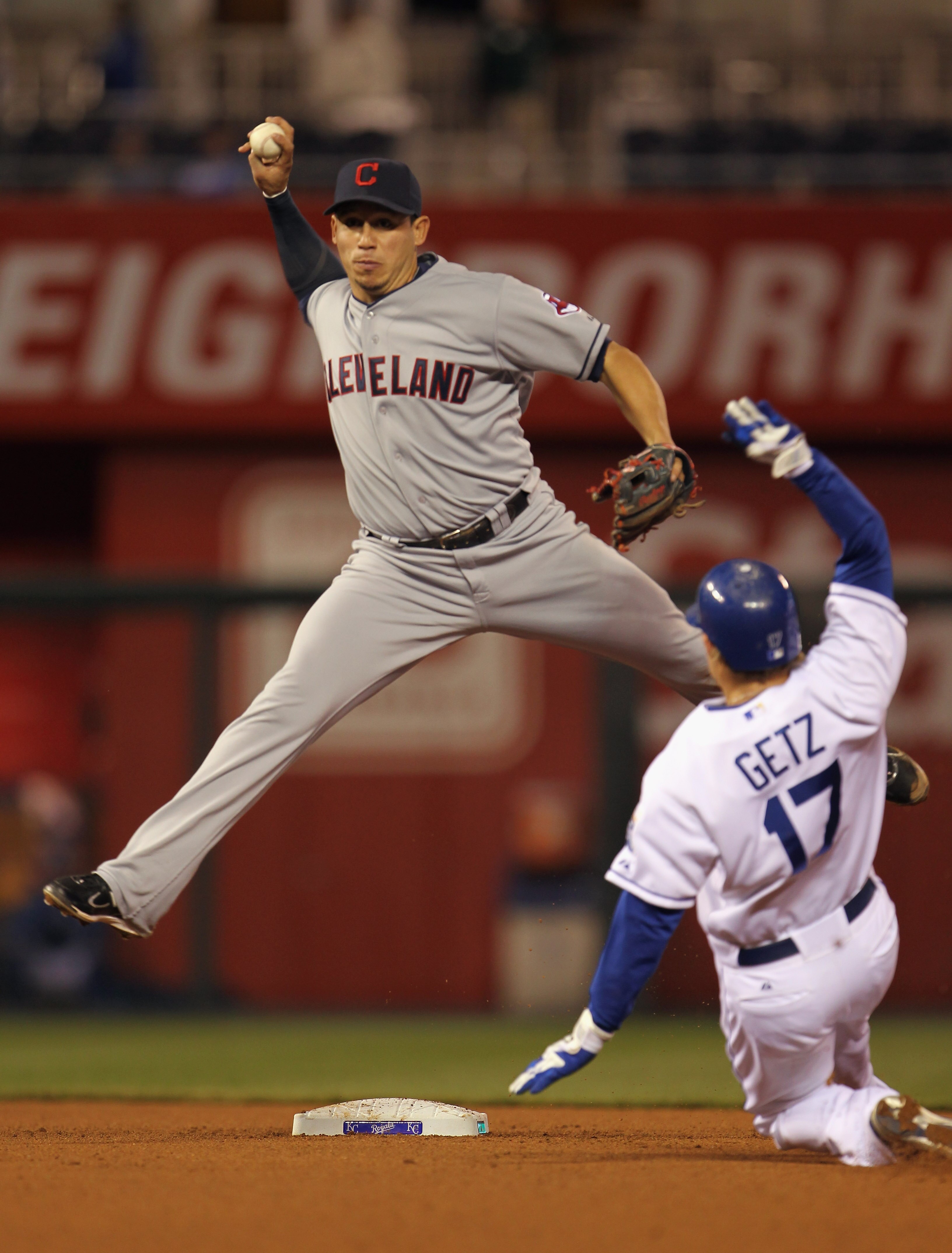 KANSAS CITY, MO - APRIL 20:  Orlando Cabrera #20 of the Cleveland Indians throws to first while attempting a double play as Chris Getz #17 of the Kansas City Royals slides into second during the game on April 20, 2011 at Kauffman Stadium in Kansas City, M