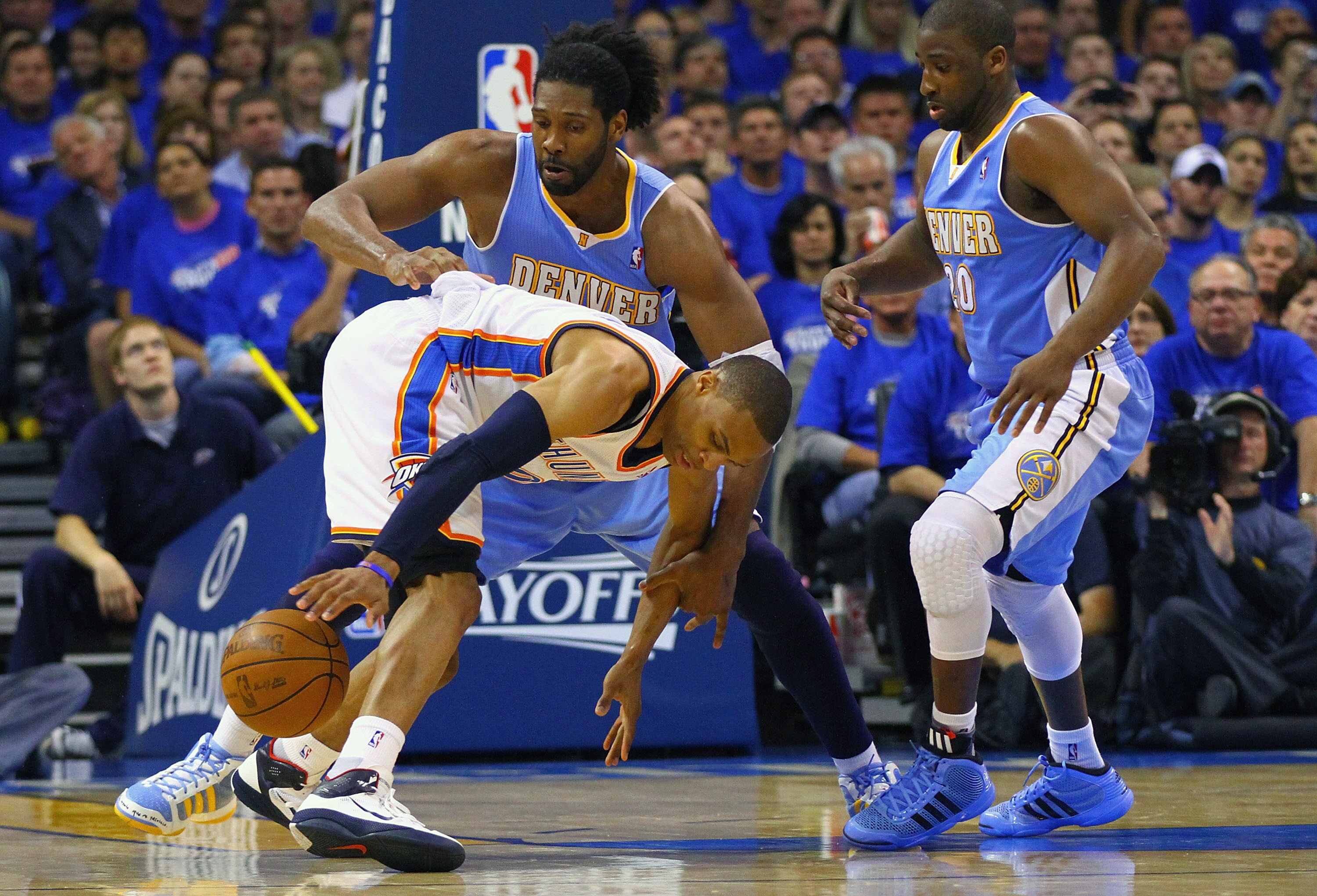 OKLAHOMA CITY, OK - APRIL 20: Russell Westbrook #0 of the Oklahoma City Thunder looses control of the ball against Nene Hilario #31 \and Raymond Felton #20 both of the Denver Nuggets in Game Two of the Western Conference Quarterfinals in the 2011 NBA Play