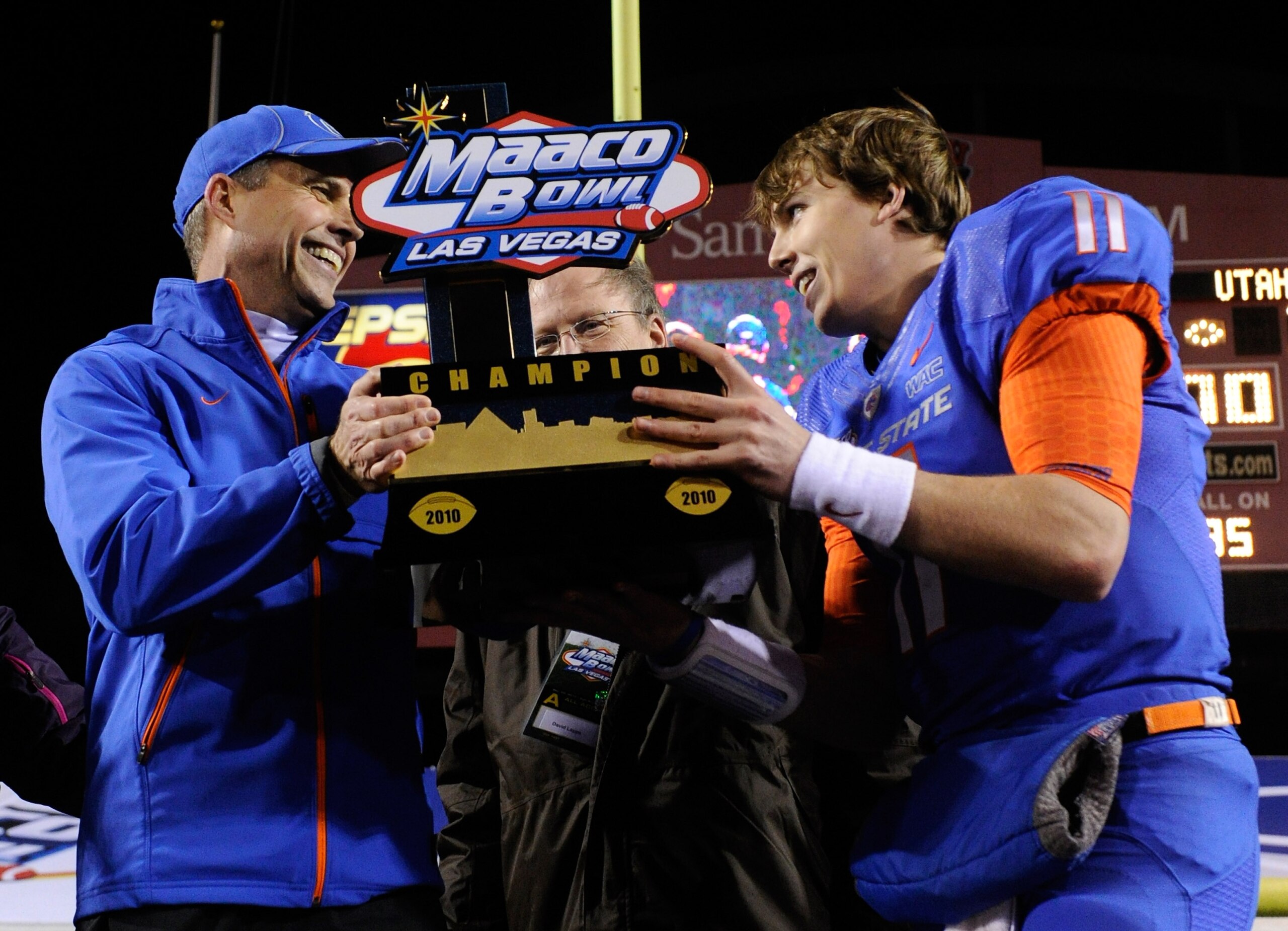 LAS VEGAS, NV - DECEMBER 22:  Head coach Chris Petersen (L) and quarterback Kellen Moore #11 of the Boise State Broncos hold up a trophy as they celebrate their 26-3 victory over the Utah Utes in the MAACO Bowl Las Vegas at Sam Boyd Stadium December 22, 2