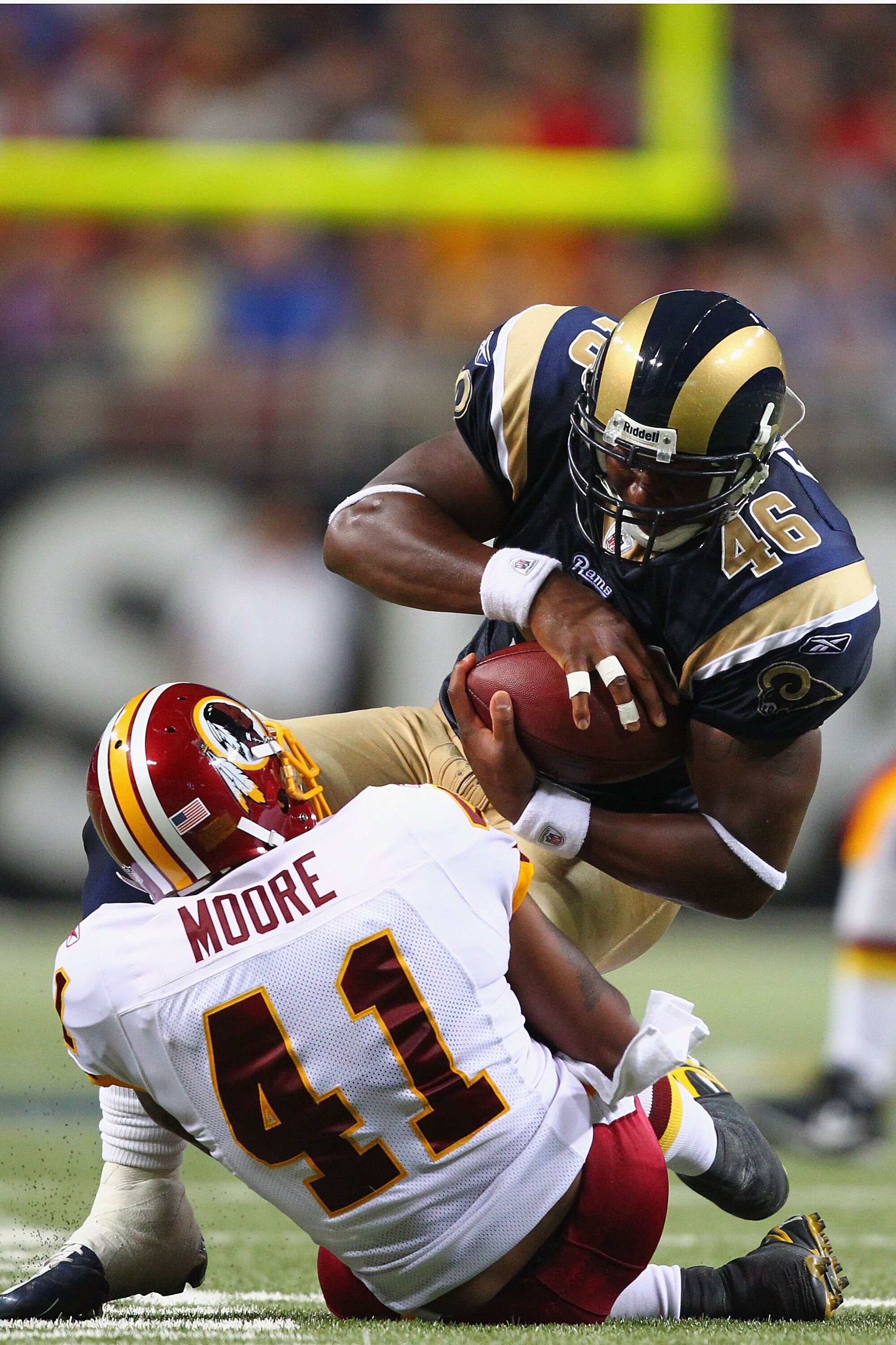 ST. LOUIS - SEPTEMBER 26: Daniel Fells #46 of the St. Louis Rams is tackled by Kareem Moore #41 of the Washington Redskins at the Edward Jones Dome on September 26, 2010 in St. Louis, Missouri.  The Rams beat the Redskins 30-16.  (Photo by Dilip Vishwanat
