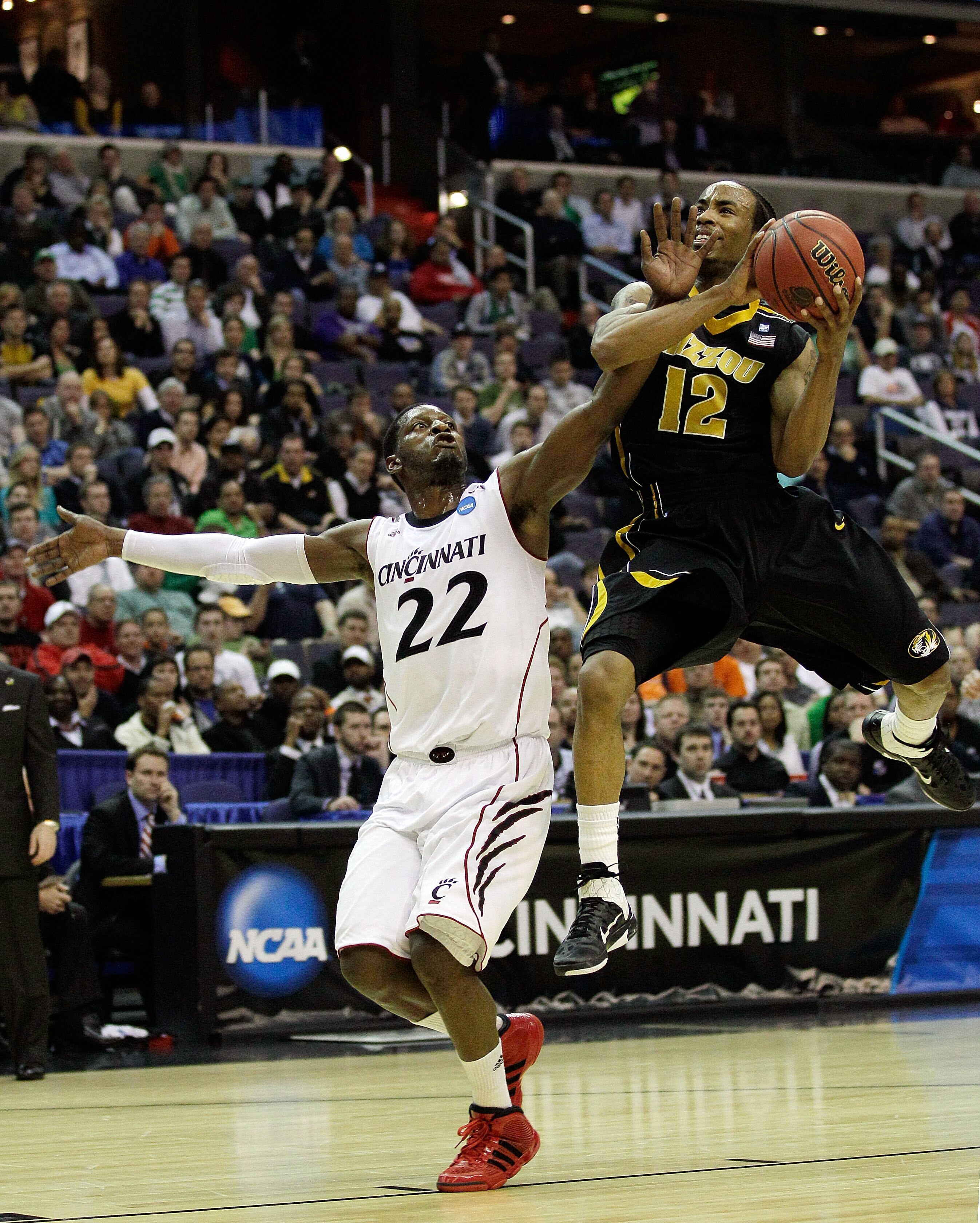 WASHINGTON - MARCH 17:  Marcus Denmon #12 of the Missouri Tigers goes up for a shot against Rashad Bishop #22 of the Cincinnati Bearcats during the second round of the 2011 NCAA men's basketball tournament at the Verizon Center on March 17, 2011 in Washin