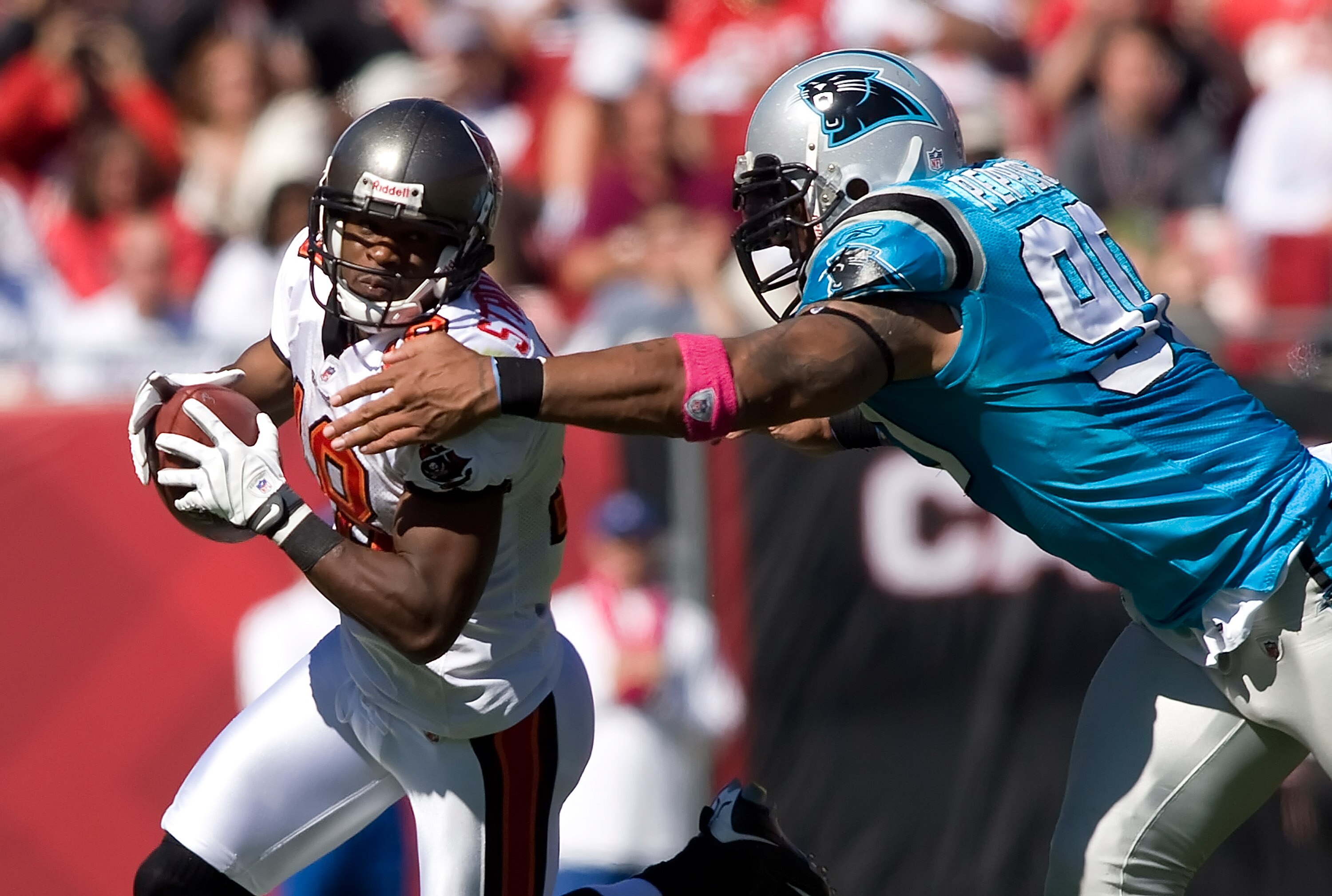 TAMPA, FL - OCTOBER 18:  Receiver Sammie Stroughter #18 of the Tampa Bay Buccaneers is tackled by defensive end Julius Peppers #90 of the Carolina Panthers during the game at Raymond James Stadium on October 18, 2009 in Tampa, Florida.  (Photo by J. Meric
