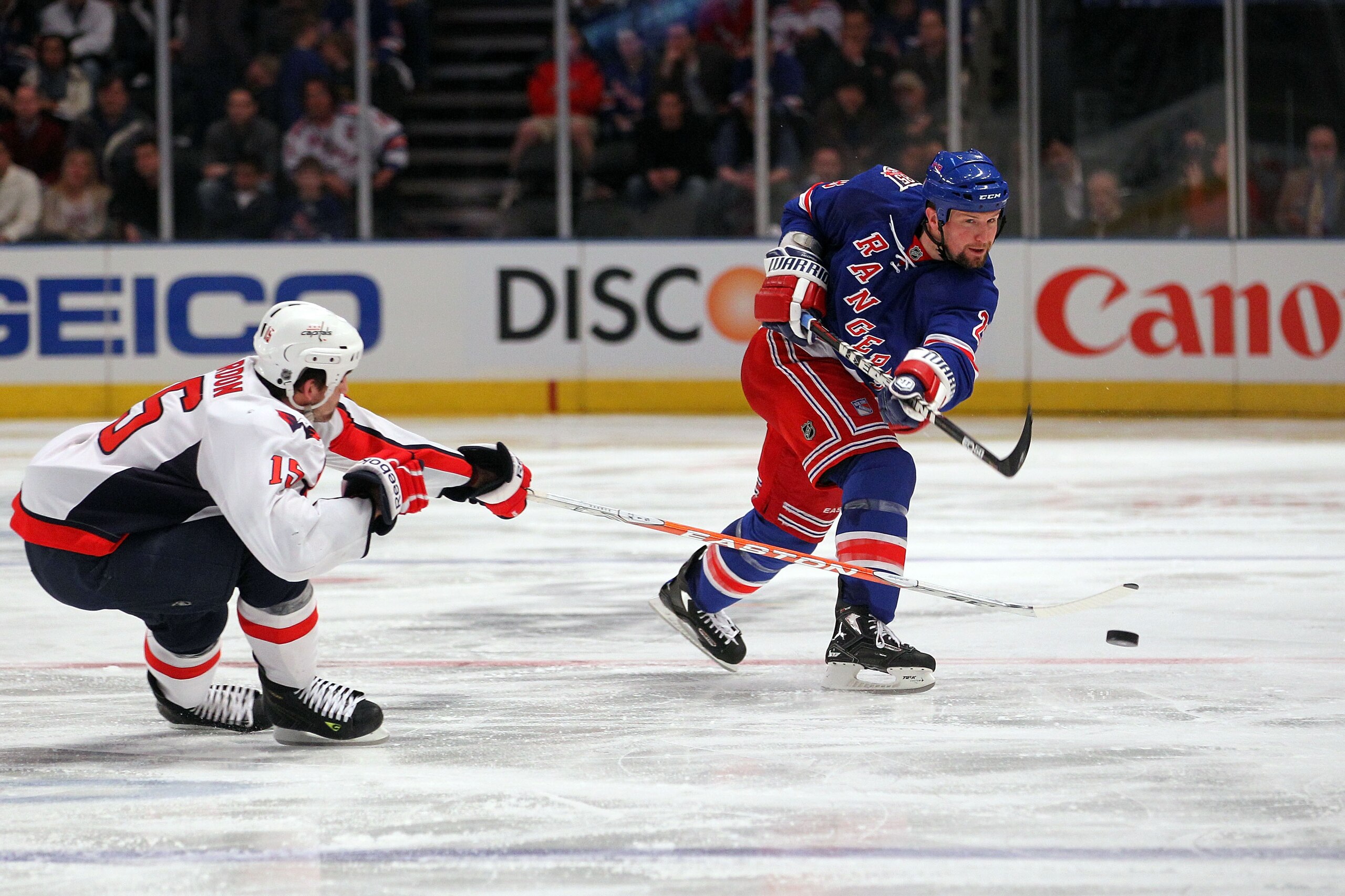 NEW YORK, NY - APRIL 17: Bryan McCabe #28 of the New York Rangers attempts a shot against Boyd Gordon #15 of the Washington Capitals in Game Three of the Eastern Conference Quarterfinals during the 2011 NHL Stanley Cup Playoffs at Madison Square Garden on