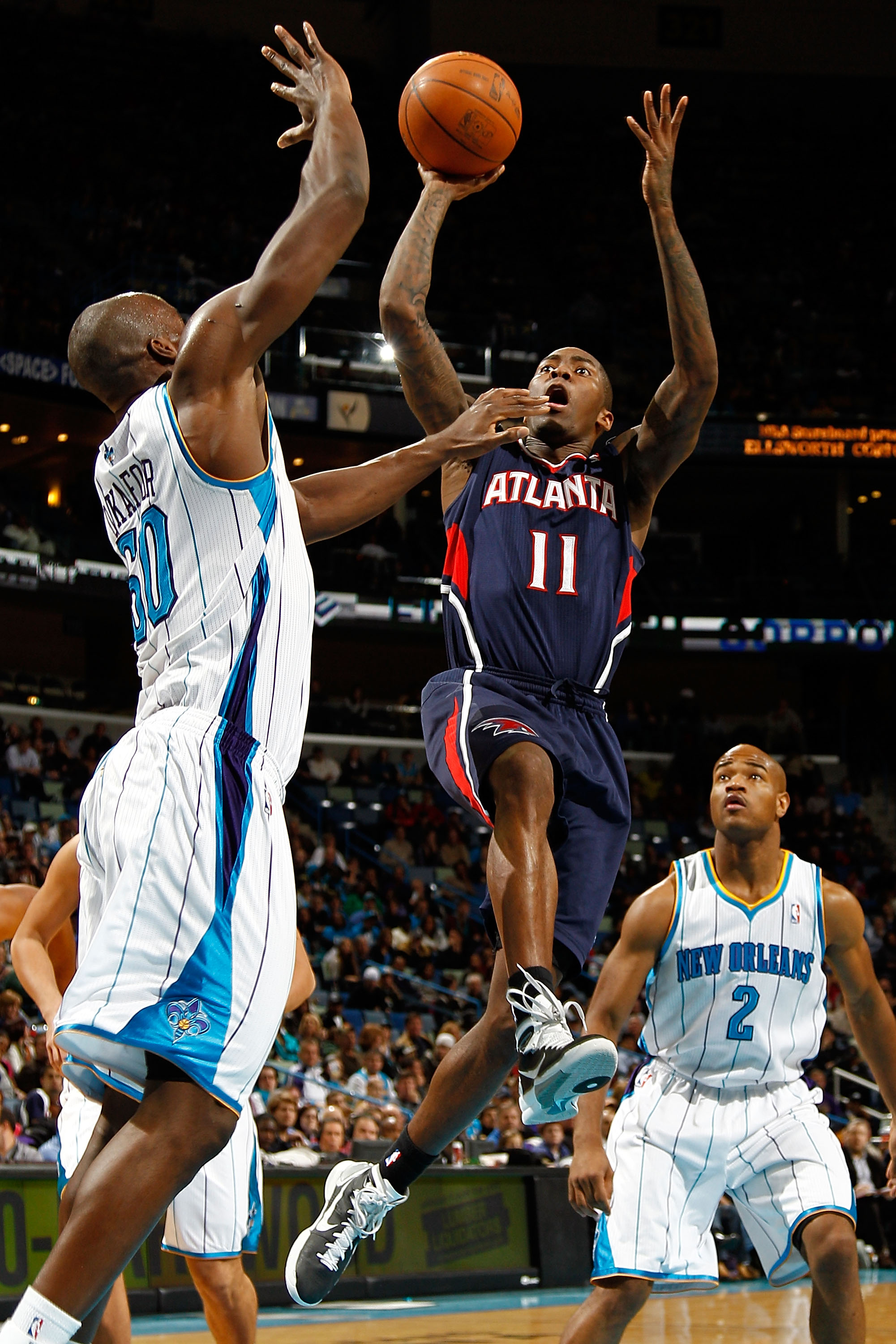 NEW ORLEANS, LA - DECEMBER 26:  Jamal Crawford #11 of the Atlanta Hawks shoots the ball over Emeka Okafor #50 of the New Orleans Hornets at the New Orleans Arena on December 26, 2010 in New Orleans, Louisiana.  The Hornets defeated the Hawks 93-86.  NOTE