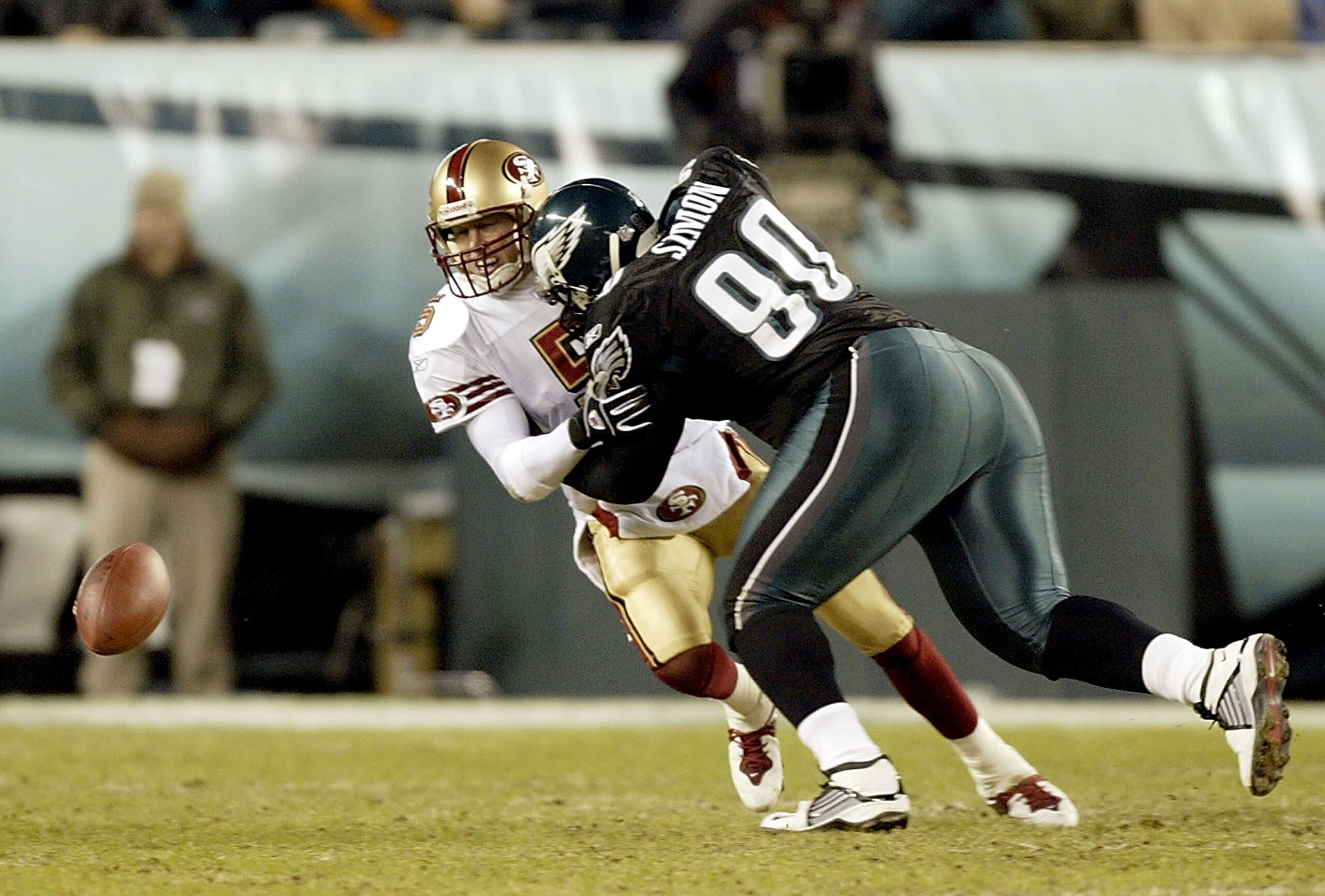 PHILADELPHIA - DECEMBER 21:  Quarterback Jeff Garcia #5 of the San Francisco 49ers fumbles the ball after being hit by Corey Simon #90 of the Philadelphia Eagles on December 21, 2003 at Lincoln Financial Field in Philadelphia, Pennsylvania.  (Photo by Ezr