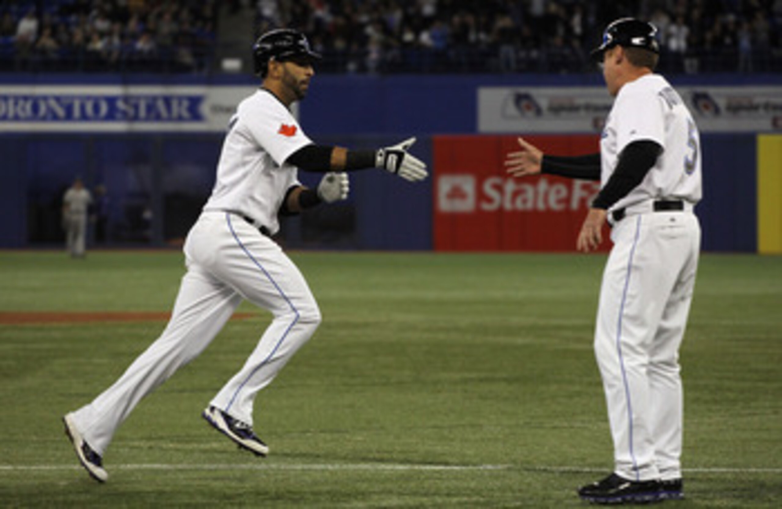 TORONTO, ON - APRIL 19:  Jose Bautista #19 (L) of the Toronto Blue Jays celebrates with coach Brian Butterfield #55 after Bautista's first inning home run during their game against the New York Yankees at Rogers Centre on April 19, 2011 in Toronto, Canada
