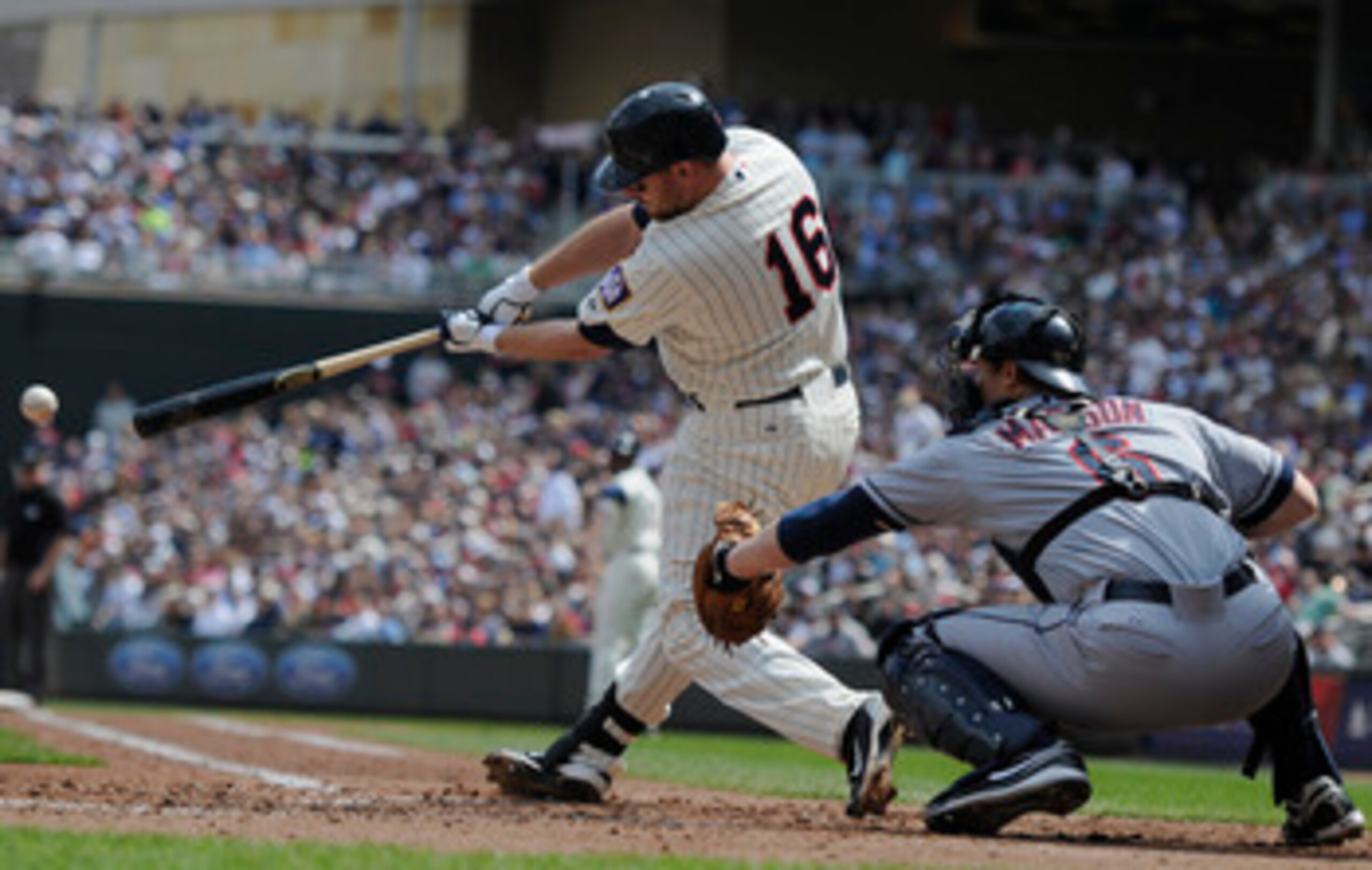 MINNEAPOLIS, MN - APRIL 24: Jason Kubel #16 of the Minnesota Twins hits a single as Lou Marson #6 of the Cleveland Indians defends home plate during the third inning of their game on April 24, 2011 at Target Field in Minneapolis, Minnesota. Twins defeated