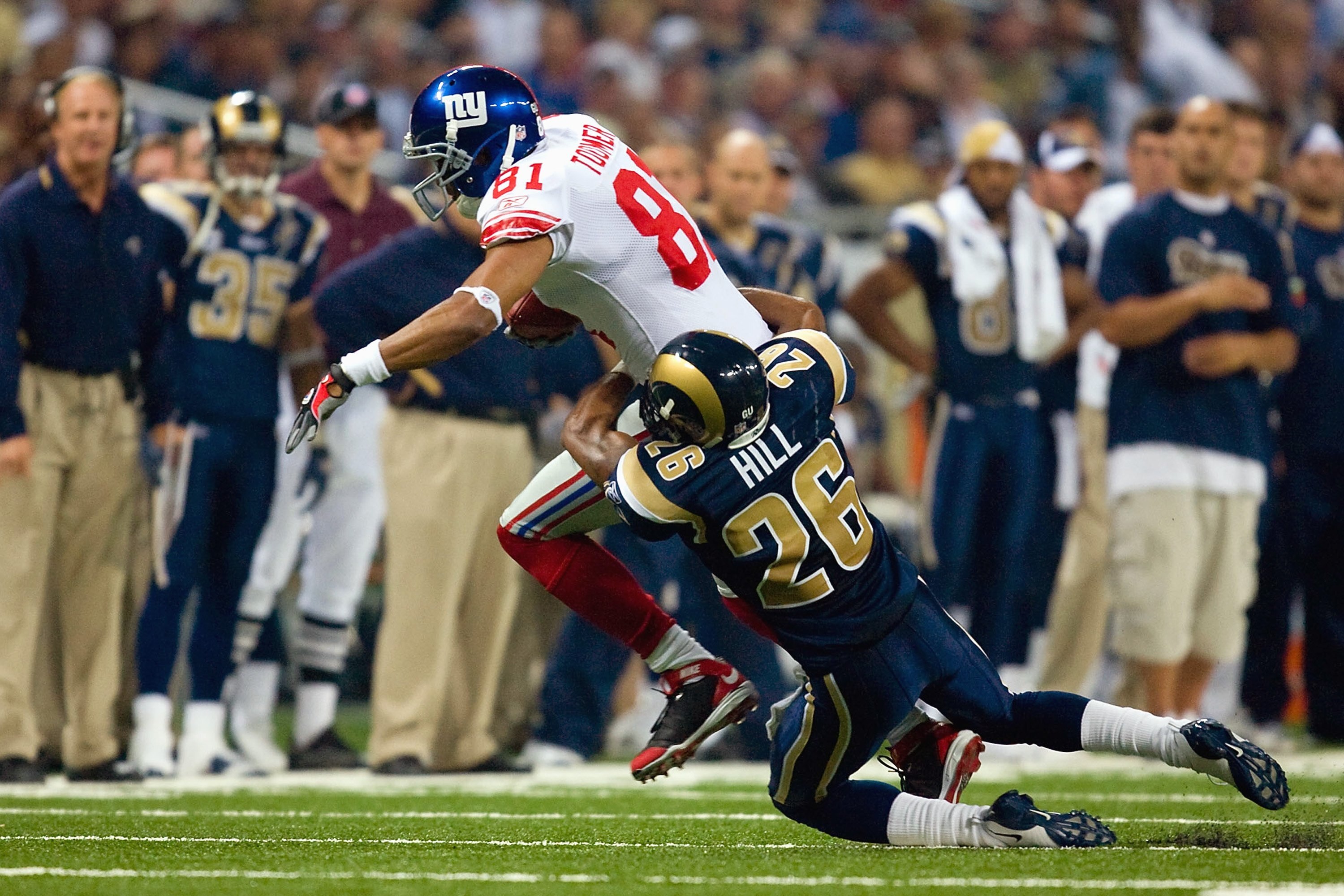 ST. LOUIS, MO - SEPTEMBER 14:  Amani Toomer #81 of the New York Giants carries the ball as he is tackled by Tye Hill #26 of the St. Louis Rams at Edward Jones Dome on September 14, 2008 in St. Louis, Missouri. (Photo by Dilip Vishwanat/Getty Images)