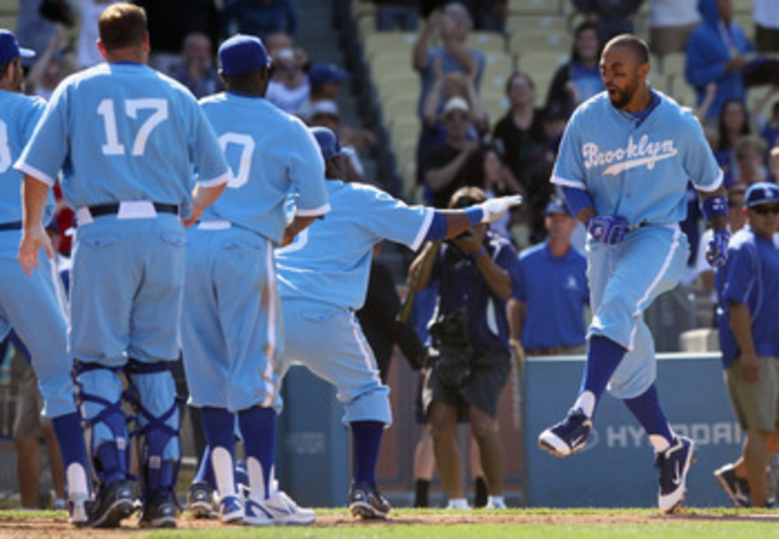 LOS ANGELES, CA - APRIL 21:  Matt Kemp (R) #27 of the Los Angeles Dodgers celebrates with his teammates at home plate after hitting a two-run home run to win the game in the 12th inning against the Atlanta Braves at Dodger Stadium on April 21, 2011 in Los