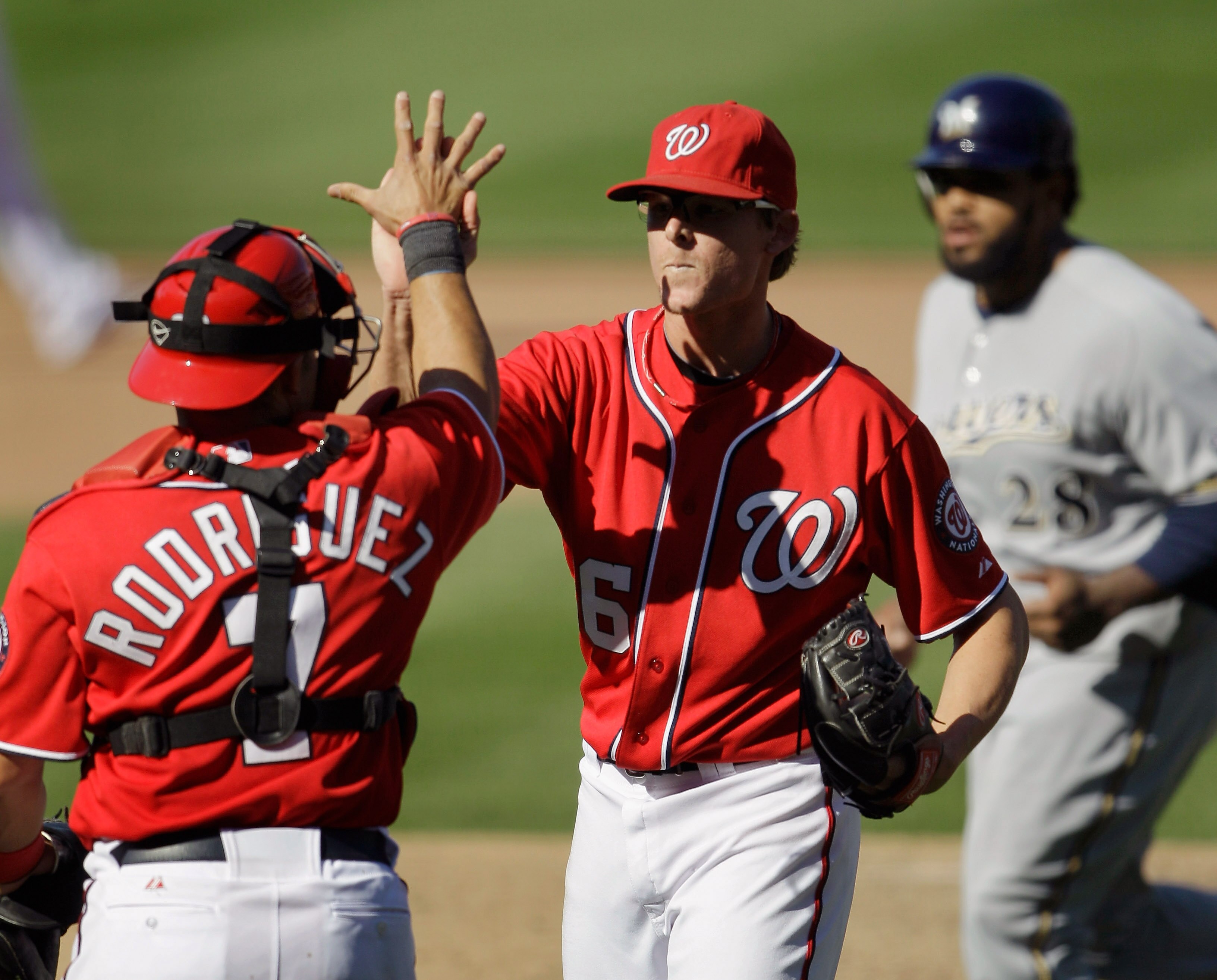 WASHINGTON, DC - APRIL 17: Prince Fielder #28 of the Milwaukee Brewers (R) walks off the field as Ivan Rodriguez #7 of the Washington Nationals celebrates with pitcher Tyler Clippard #36 after defeating the  Brewers 8-4 during the first game of a doublehe