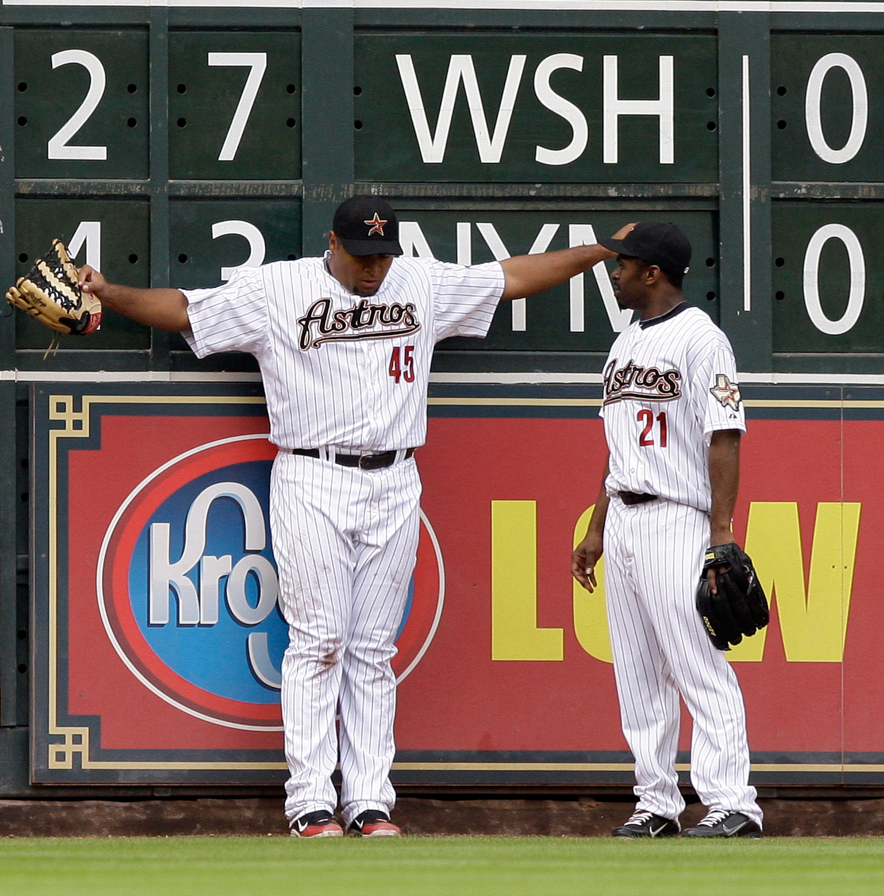 HOUSTON - APRIL 08:  Left fielder Carlos Lee #45 of the Houston Astros takes a moment to regain his composure after slamming into the wall to make a catch at Minute Maid Park on April 8, 2011 in Houston, Texas. Center fielder Michael Bourn checks with Lee