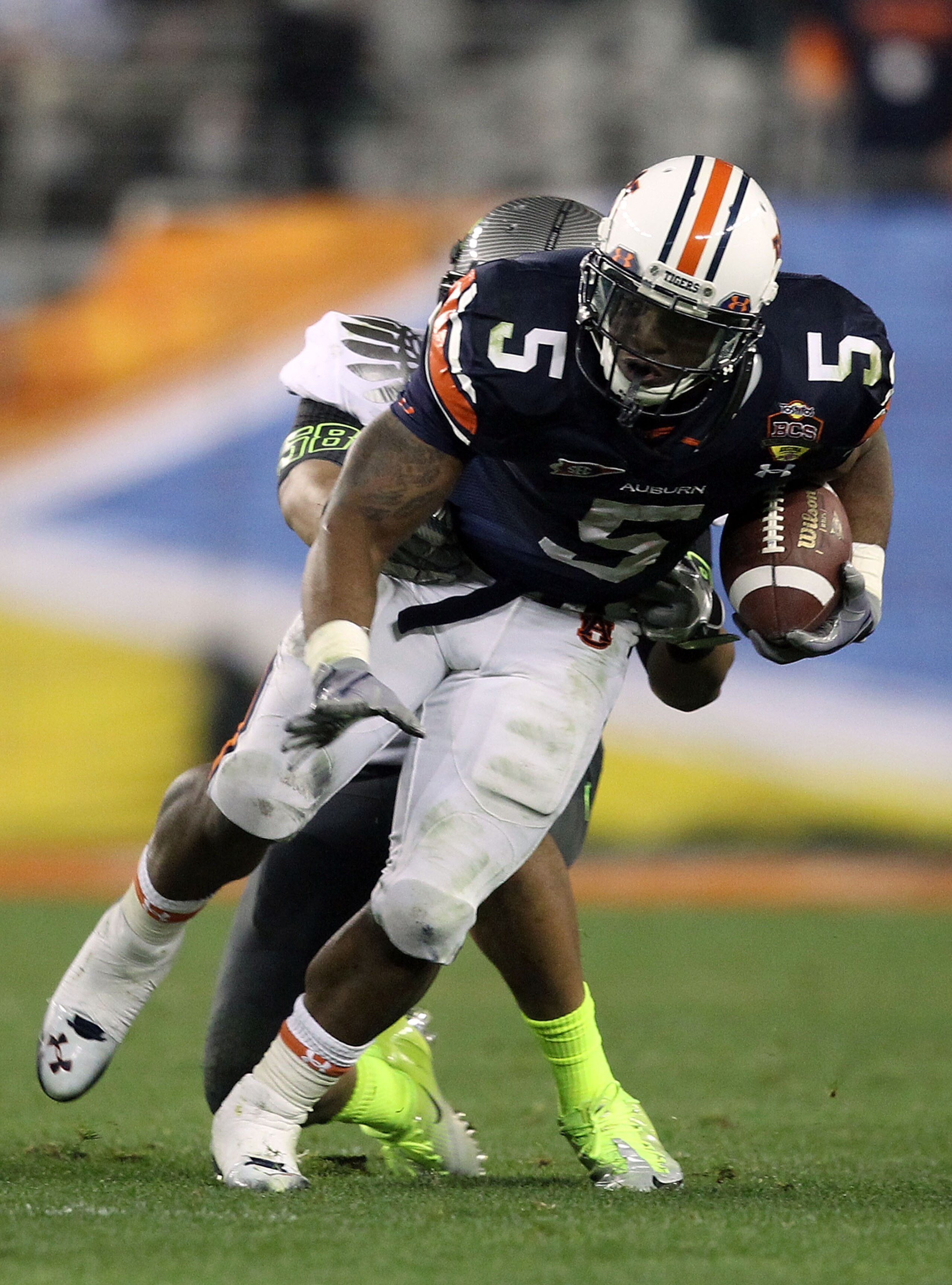 GLENDALE, AZ - JANUARY 10:  Michael Dyer #5 of the Auburn Tigers is tackled by Kenny Rowe #58 of the Oregon Ducks during the Tostitos BCS National Championship Game at University of Phoenix Stadium on January 10, 2011 in Glendale, Arizona.  (Photo by Chri