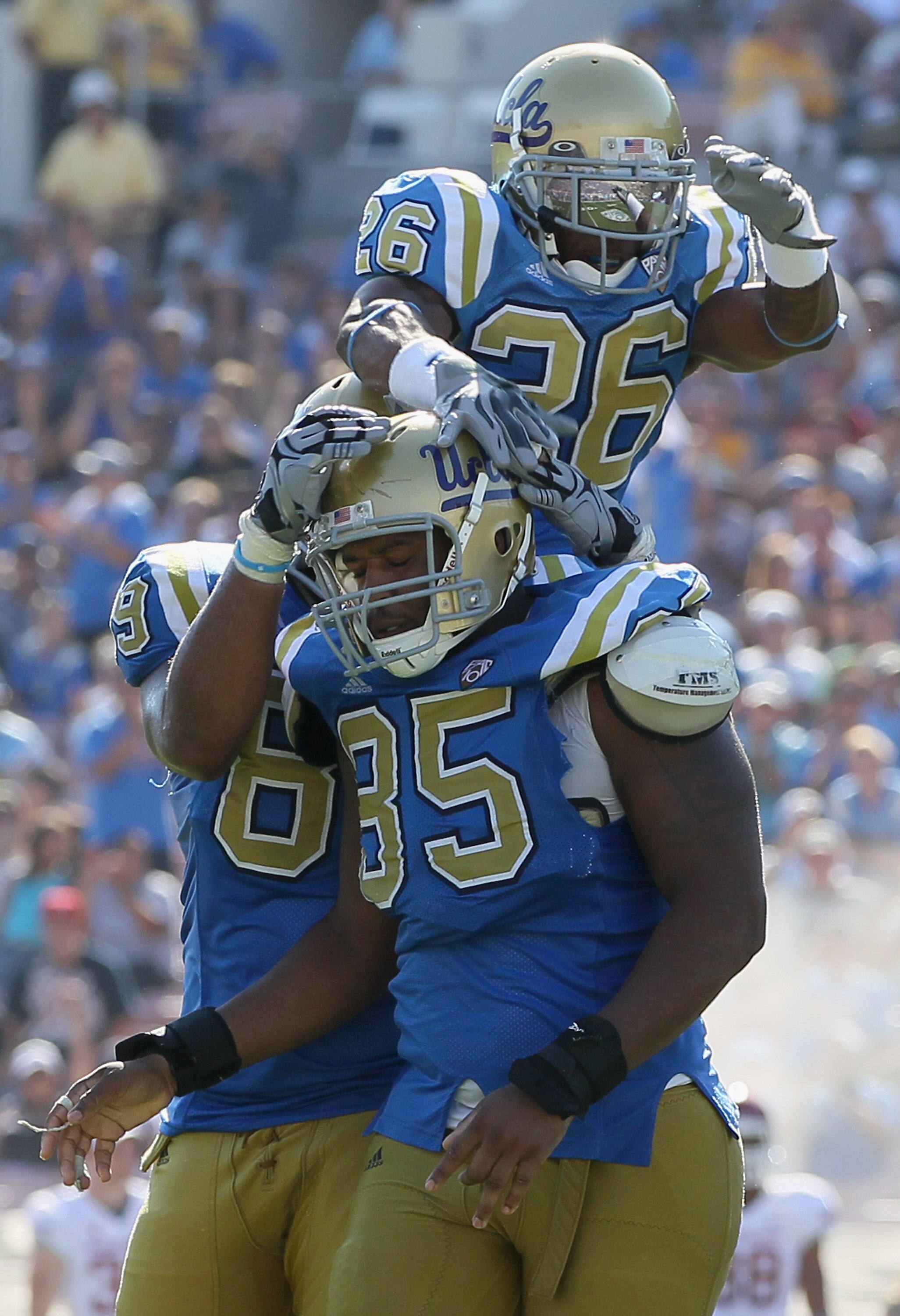 PASADENA, CA - OCTOBER 02:  Andrew Abbott #26 of the UCLA Bruins jumps onto the shoulders of teammate David Carter #85 after Carter's sack of  Washington State quarterback Jeff Tuel during the fourth quarter at the Rose Bowl on October 2, 2010 in Pasadena