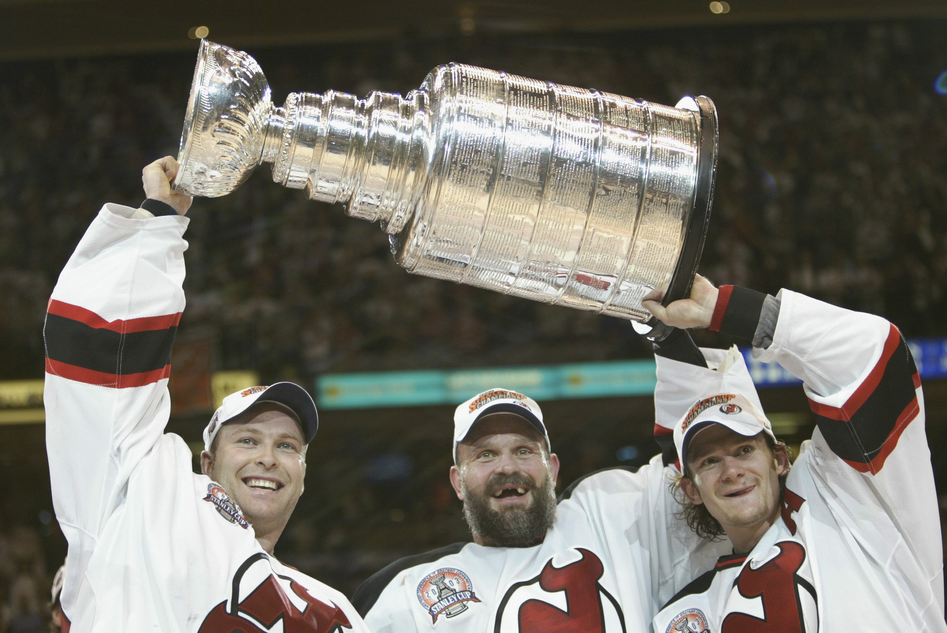 EAST RUTHERFORD, NJ - JUNE 9:  (L-R) Goalie Martin Brodeur #30, Ken Daneyko #3 and Patrik Elias #26 of the New Jersey Devils hold up the Stanley Cup after defeating the Mighty Ducks of Anaheim 3-0 in game seven of the 2003 Stanley Cup Finals at Continenta