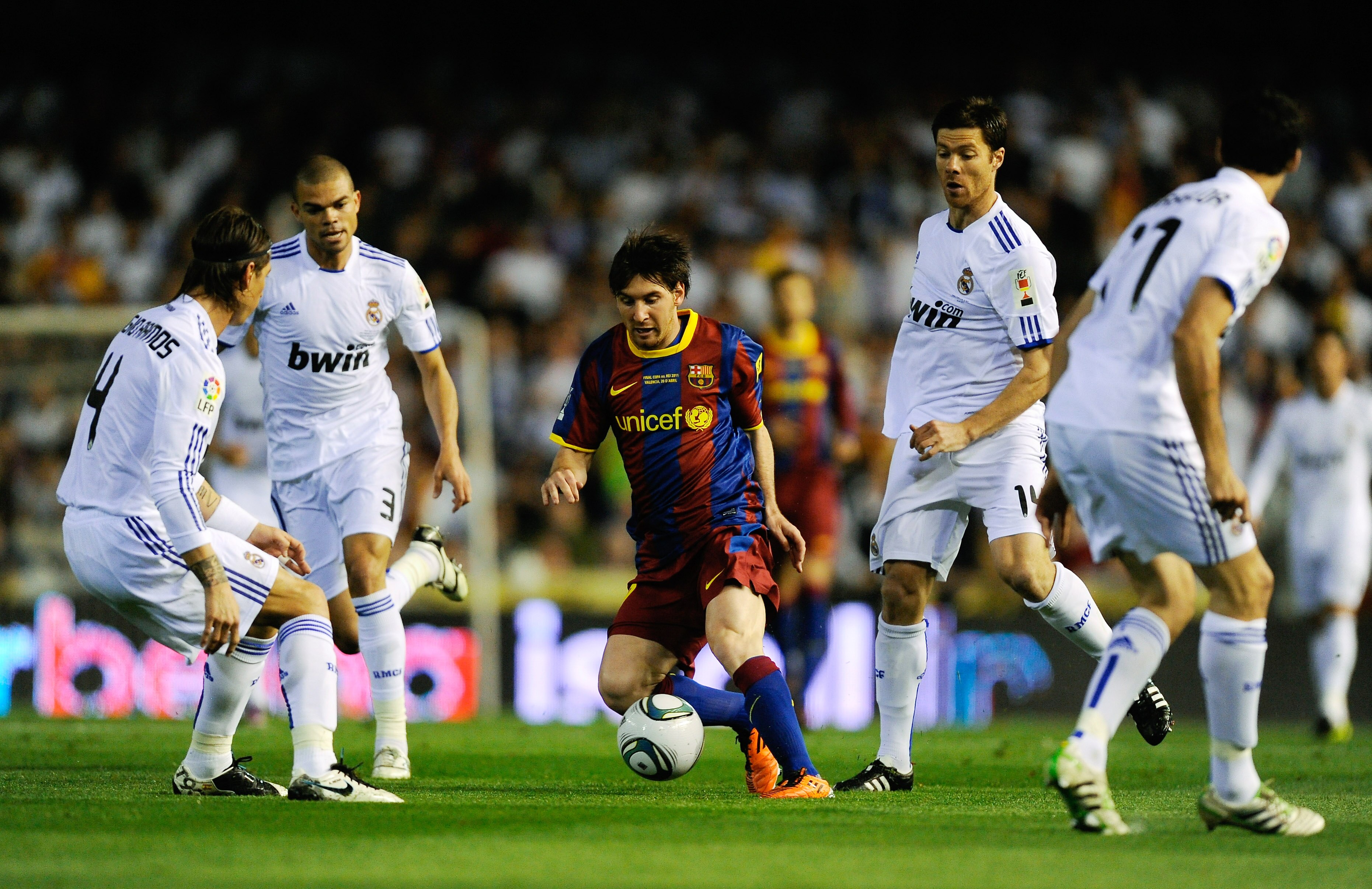 VALENCIA, SPAIN - APRIL 20: Lionel Messi of FC Barcelona (C) holds off a challenge by  Xabi Alonso of Real Madrid (2ndR) during the Copa del Rey Final between Real Madrid and Barcelona at Estadio Mestalla on April 20, 2011 in Valencia, Spain.  (Photo by D