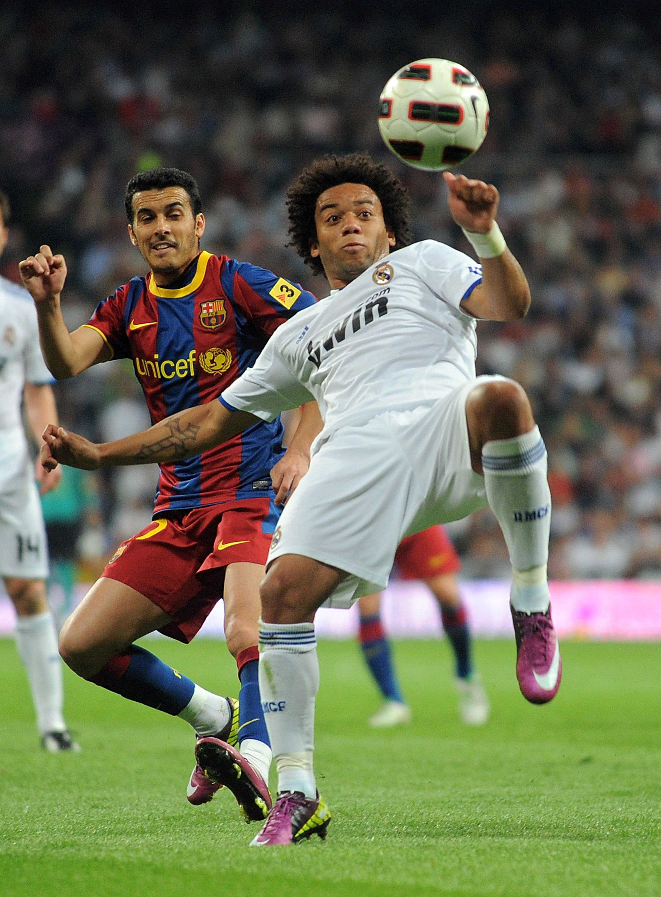 MADRID, SPAIN - APRIL 16:  Marcelo of Real Madrid clears the ball beside Pedro Rodriguez of Barcelona during the La Liga match between Real Madrid and Barcelona at Estadio Santiago Bernabeu on April 16, 2011 in Madrid, Spain.  (Photo by Denis Doyle/Getty
