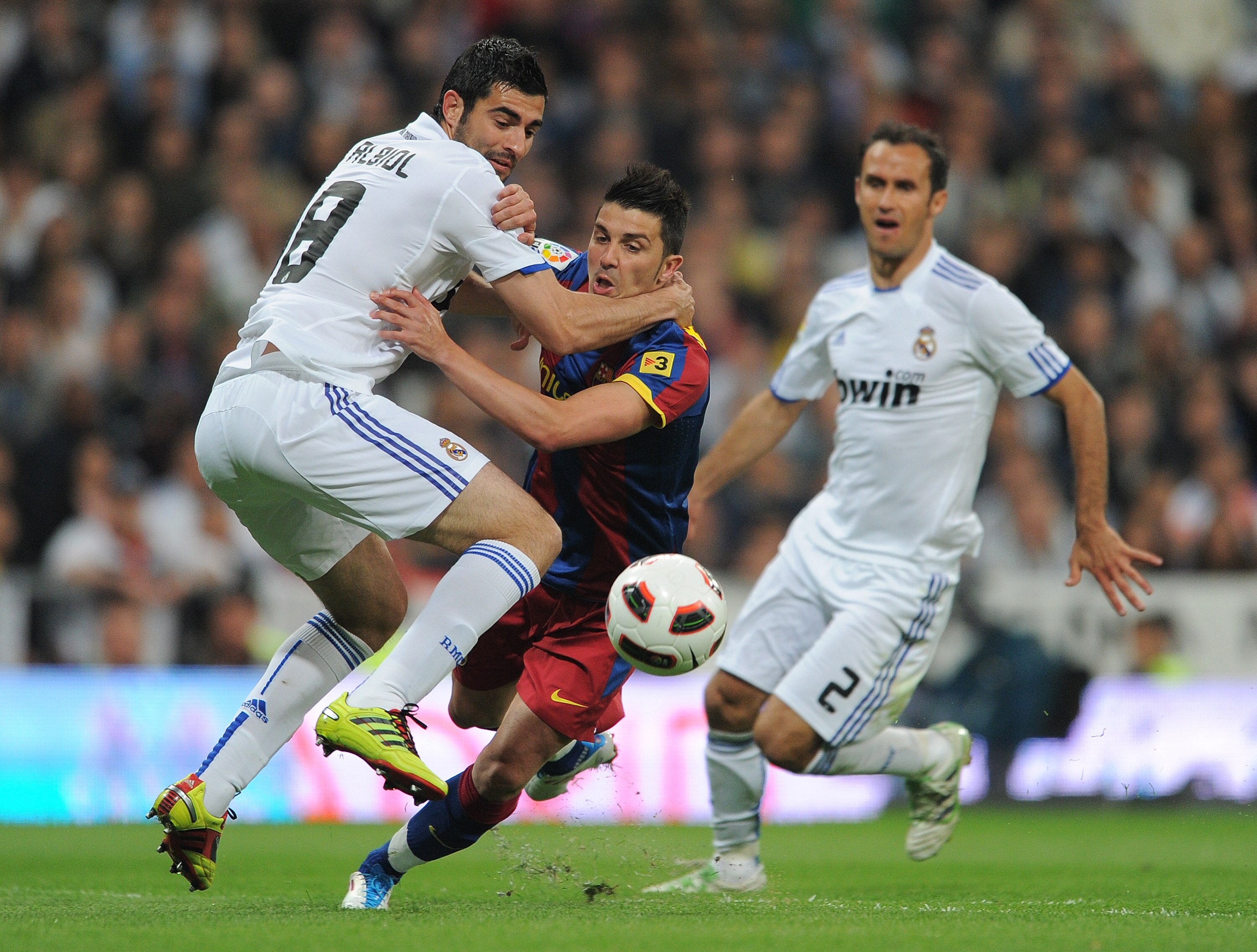 MADRID, SPAIN - APRIL 16:  Raul Albiol (L) of Real Madrid fouls David Villa (C) of Barcelona in the penalty aeria as Ricardo Carvalho looks on during the la Liga match between Real Madrid and Barcelona at Estadio Santiago Bernabeu on April 16, 2011 in Mad