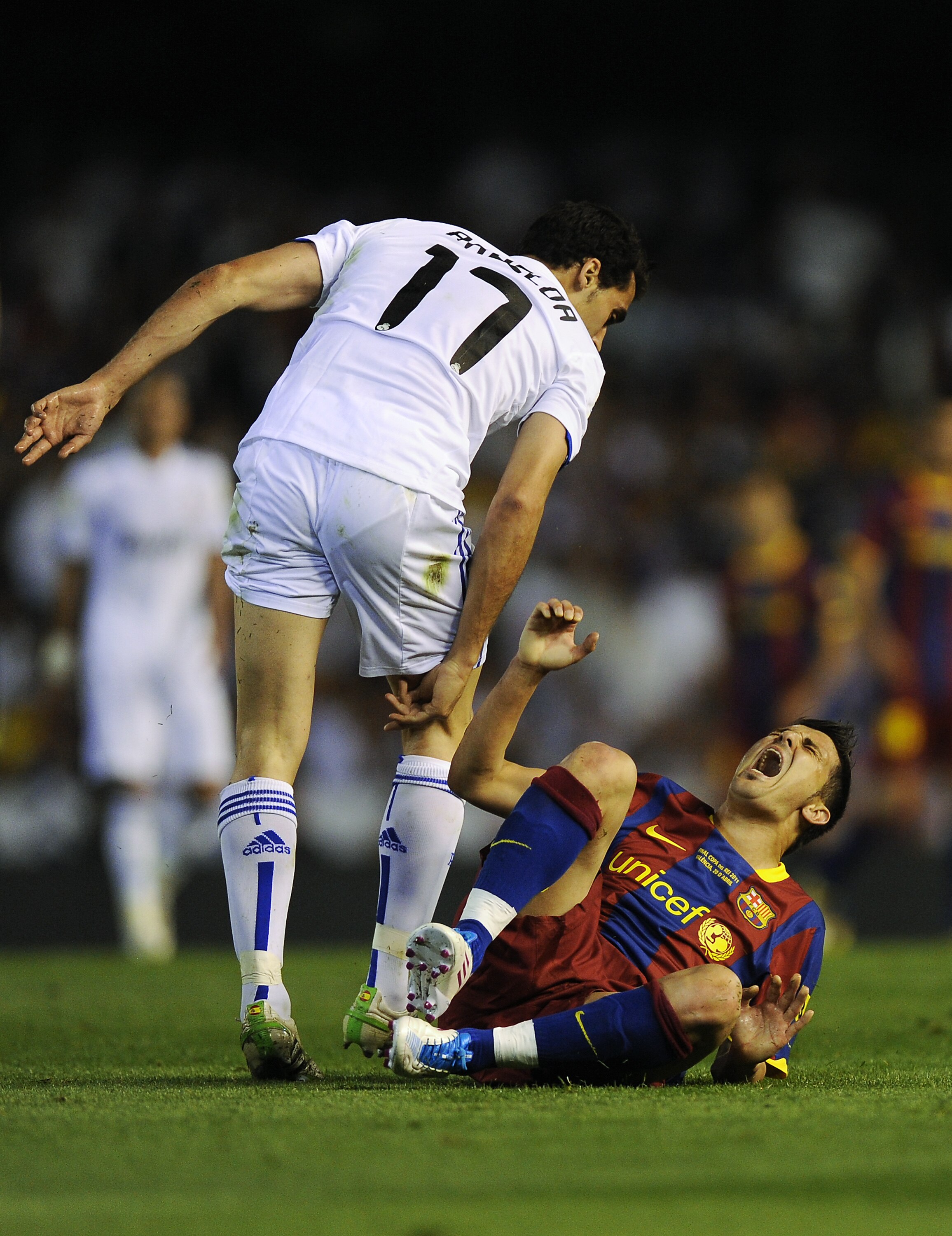 VALENCIA, SPAIN - APRIL 20:  David Villa FC Barcelona (R) reacts after being hit by Alvaro Arbeloa (C) of Real Madrid (R) during the Copa del Rey Final between Real Madrid and Barcelona at Estadio Mestalla on April 20, 2011 in Valencia, Spain.  (Photo by