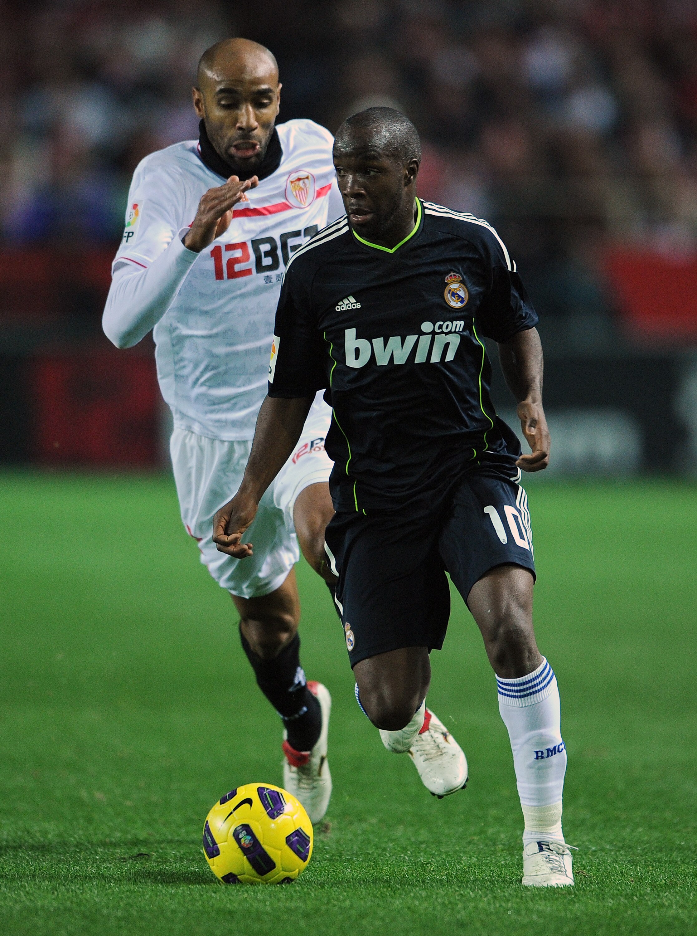 SEVILLE, SPAIN - JANUARY 26:  Lassana Diarra (R) of Real Madrid runs for the ball with Frederic Kanoute of Sevilla during the semi-final Copa del Rey first leg match between Sevilla and Real Madrid at Estadio Ramon Sanchez Pizjuan on January 26, 2011 in S