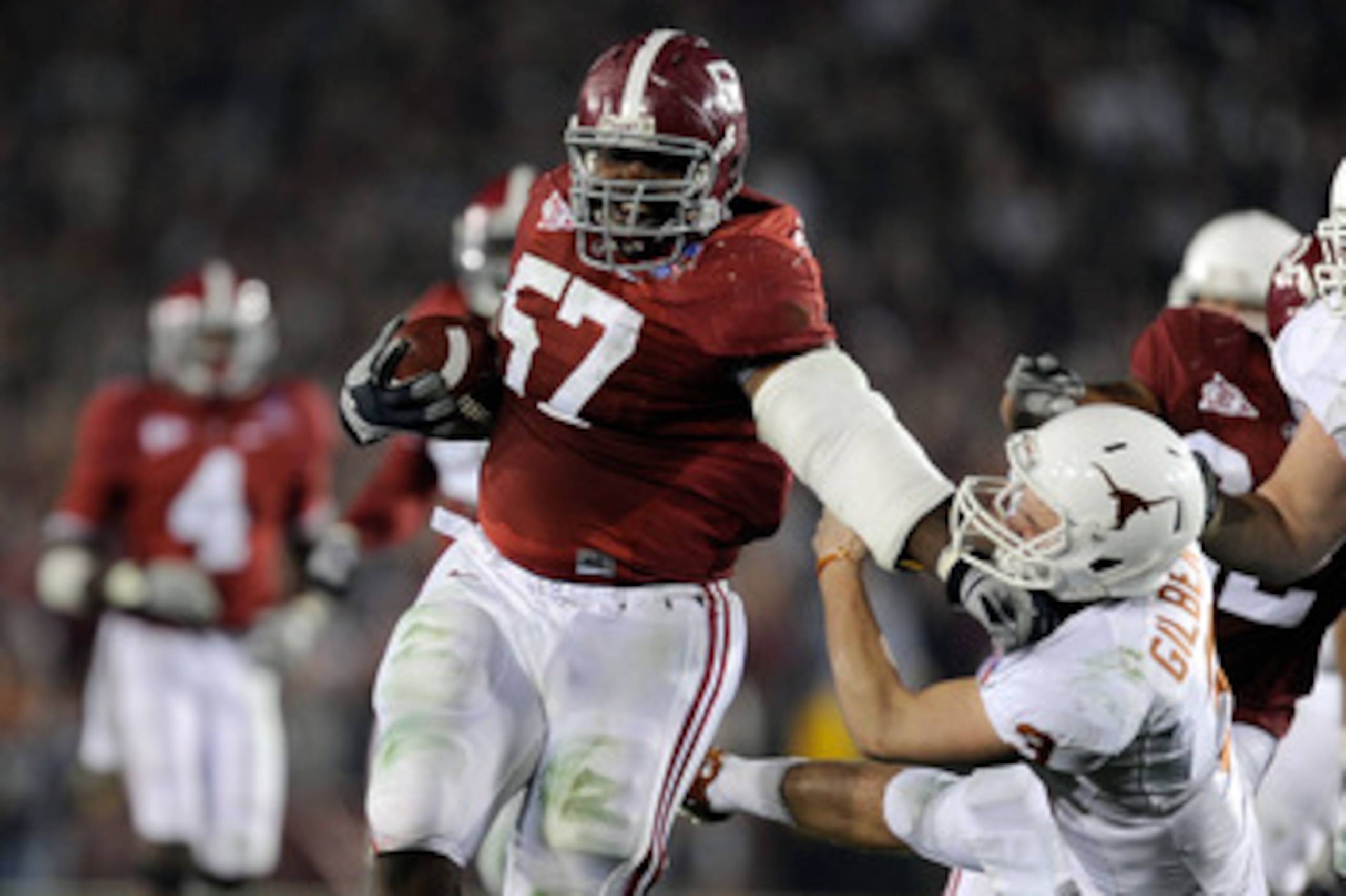 PASADENA, CA - JANUARY 07:  Quarterback Garrett Gilbert #3 of the Texas Longhorns tries to tackle lineman Marcell Dareus #57 of the Alabama Crimson Tide who would score after intercepting the ball during the second quarter of the Citi BCS National Champio