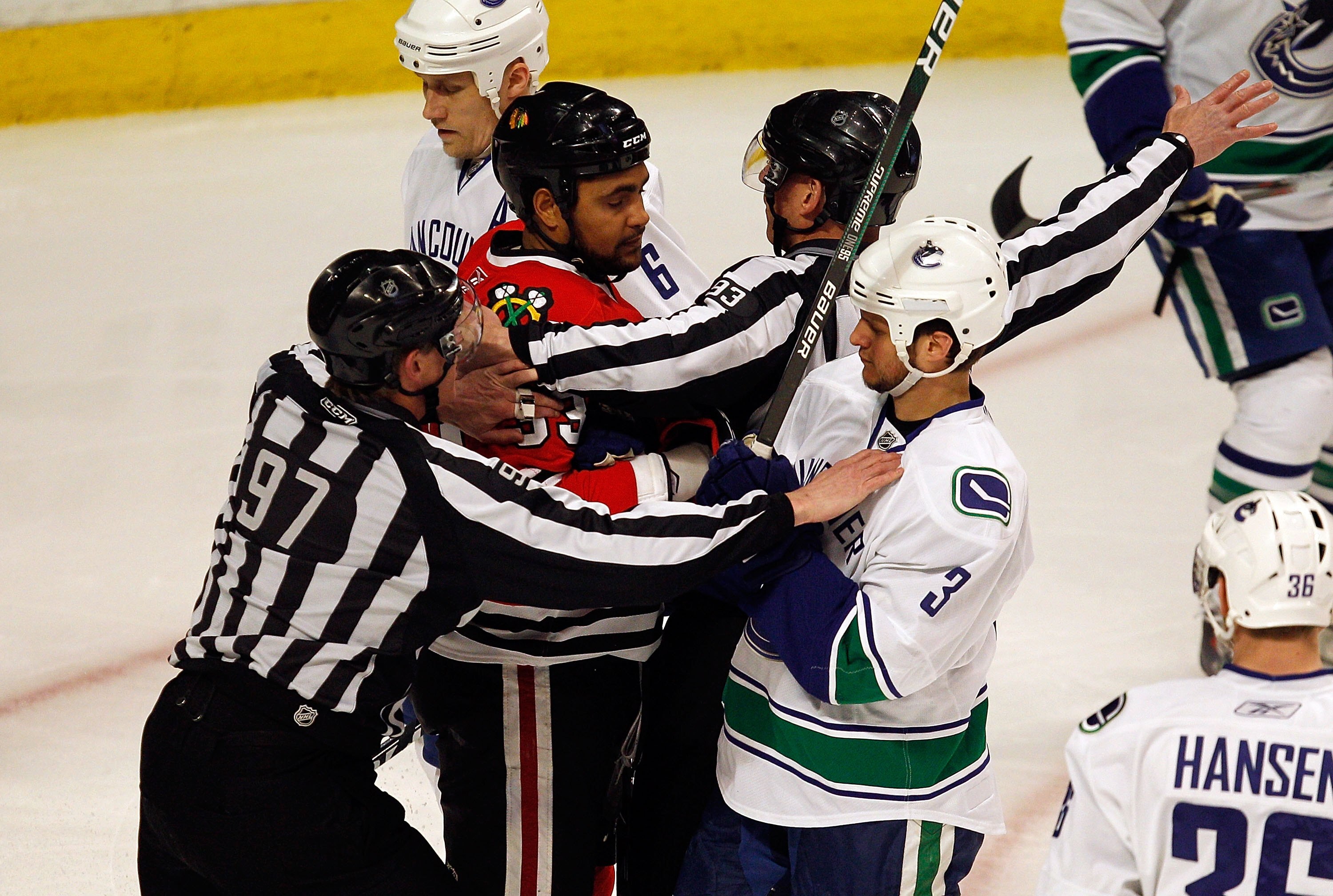 CHICAGO - MAY 01: Referees break up a confrontation between Dustin Byfuglien #33 of the Chicago Blackhawks and Kevin Bieksa #3 of the Vancouver Canucks in Game One of the Western Conference Semifinals during the 2010 NHL Stanley Cup Playoffs at United Cen