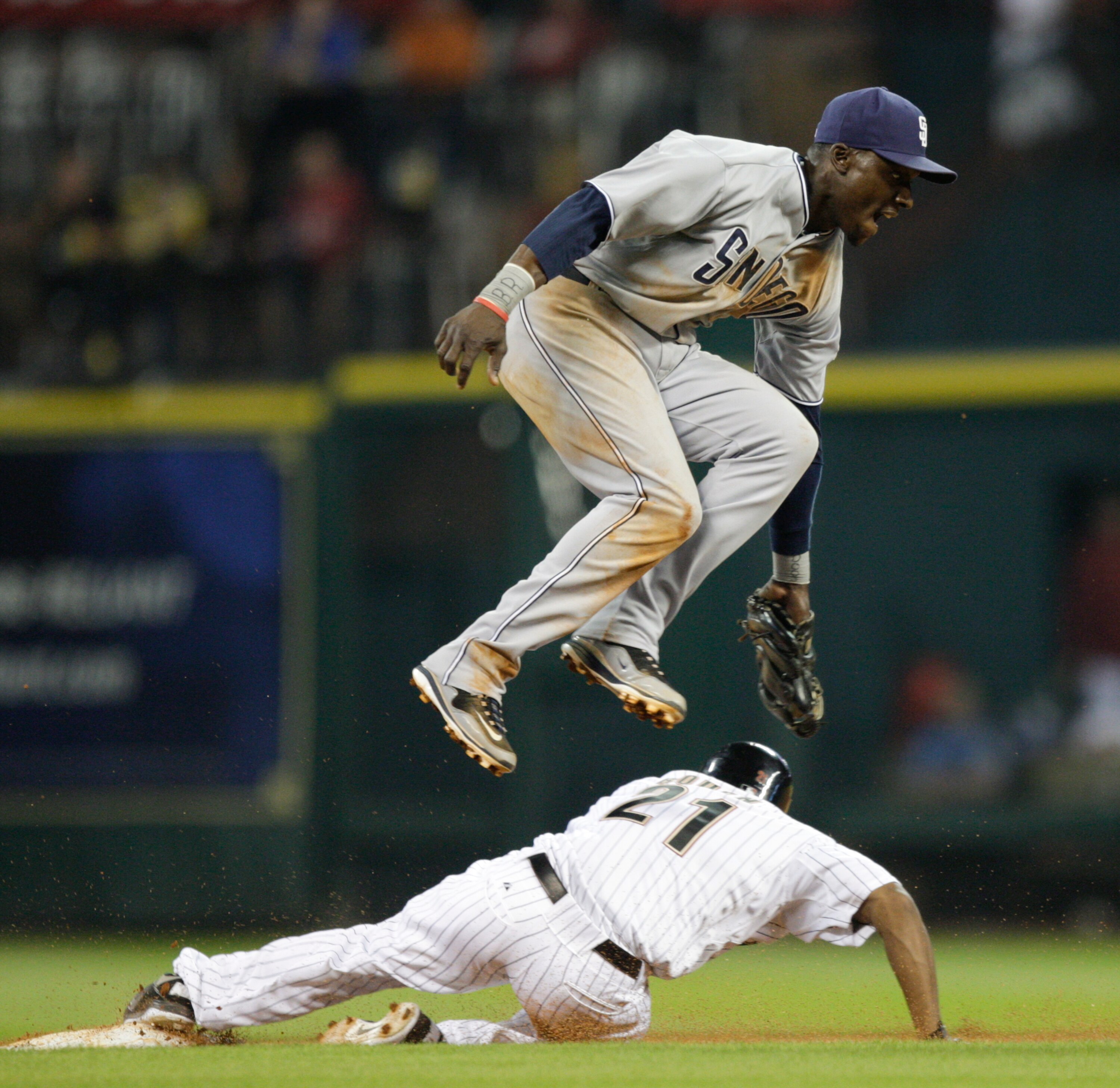 HOUSTON - APRIL 14:  Michael Bourn #21 of the Houston Astros slides underneath second baseman Orlando Hudson #1 as he attempts the tag at Minute Maid Park on April 14, 2011 in Houston, Texas.  (Photo by Bob Levey/Getty Images)