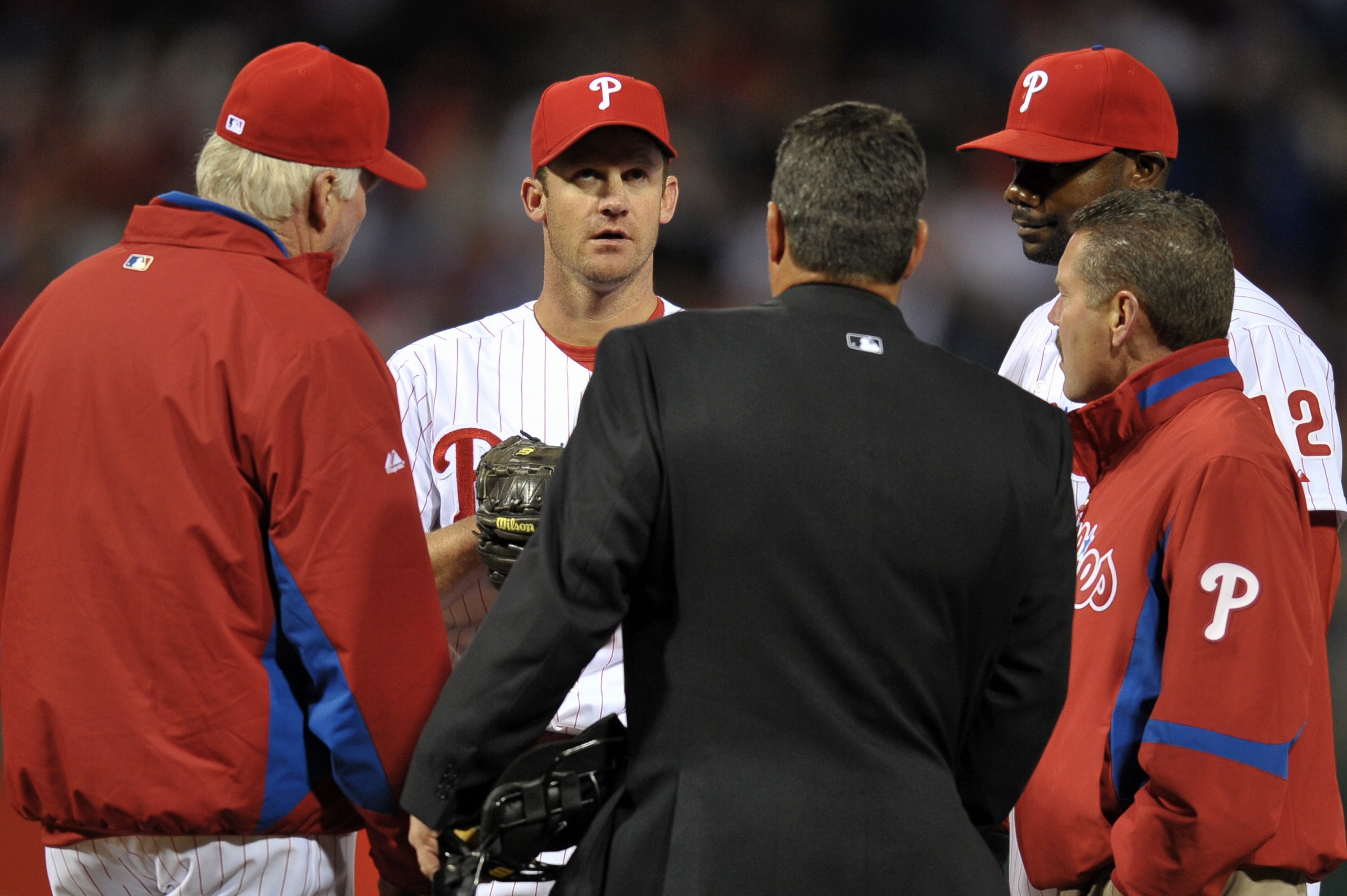 PHILADELPHIA, PA - APRIL 15: Starting pitcher Roy Oswalt #44 of the Philadelphia Phillies meets on the mound with manager Charlie Manuel, home plate umpire Rob Drake, Ryan Howard #6 and a trainer about an injury he suffered during the game against the Flo