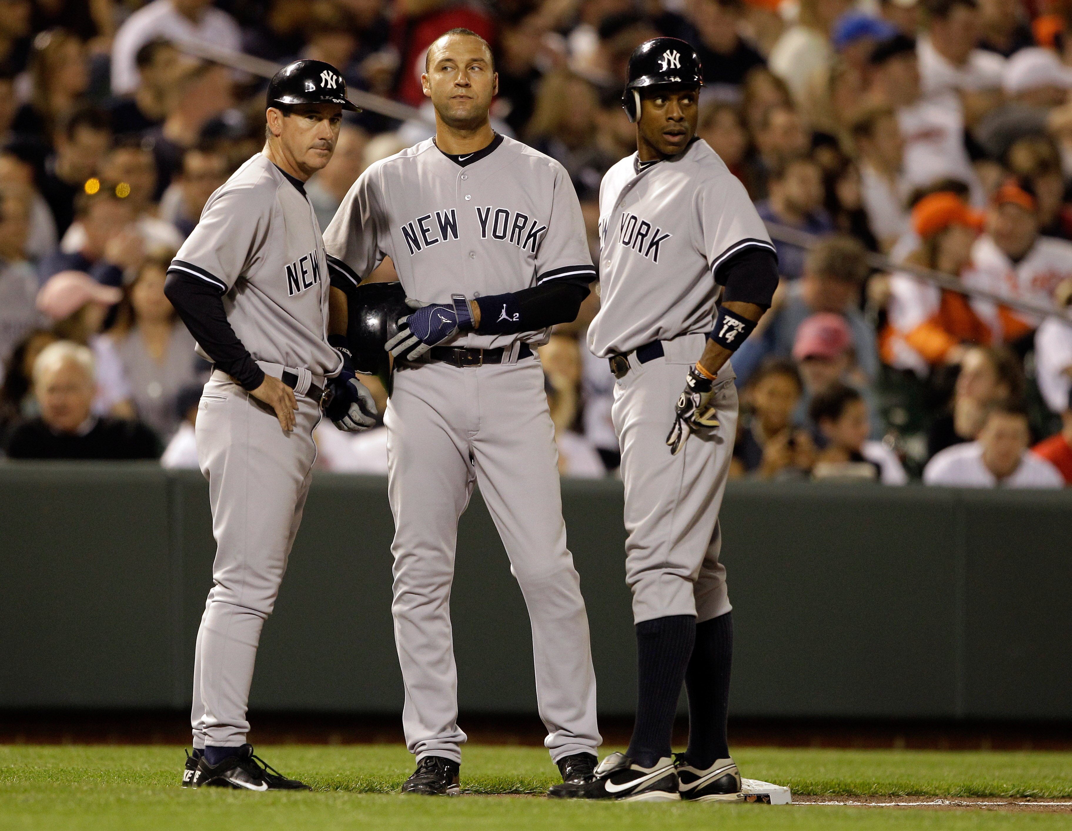 BALTIMORE, MD - APRIL 23: Third base coach Rob Thomson (L) talks with baserunners Derek Jeter #2 (C) and Curtis Granderson #14 of the New York Yankees during a pitching change against the Baltimore Orioles at Oriole Park at Camden Yards on April 23, 2011