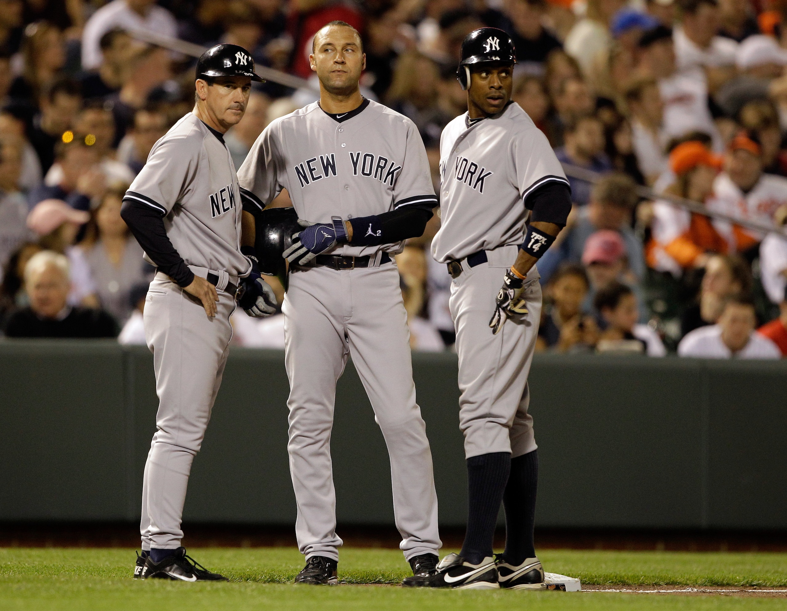 BALTIMORE, MD - APRIL 23: Third base coach Rob Thomson (L) talks with baserunners Derek Jeter #2 (C) and Curtis Granderson #14 of the New York Yankees during a pitching change against the Baltimore Orioles at Oriole Park at Camden Yards on April 23, 2011