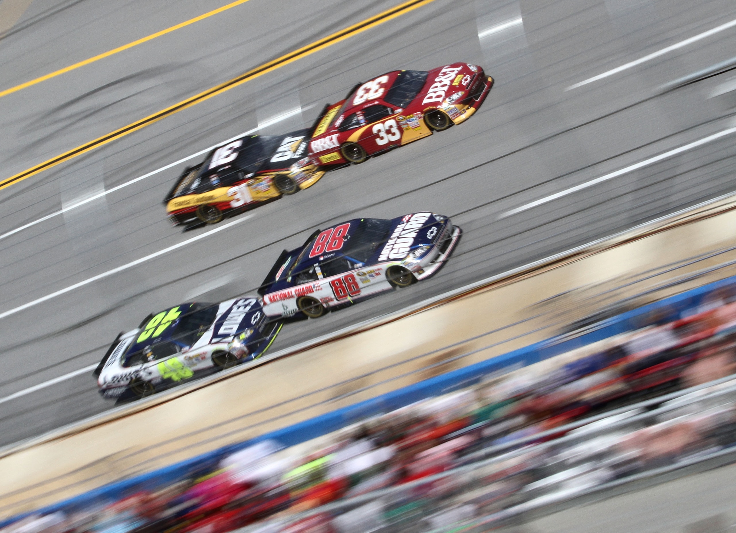 TALLADEGA, AL - APRIL 17:  Dale Earnhardt Jr., driver of the #88 National Guard/Amp Energy Chevrolet, and Jimmie Johnson, driver of the #48 Lowe's Chevrolet, race with Clint Bowyer, driver of the #33 BB&T Chevrolet, and Jeff Burton, driver of the #31 Cat
