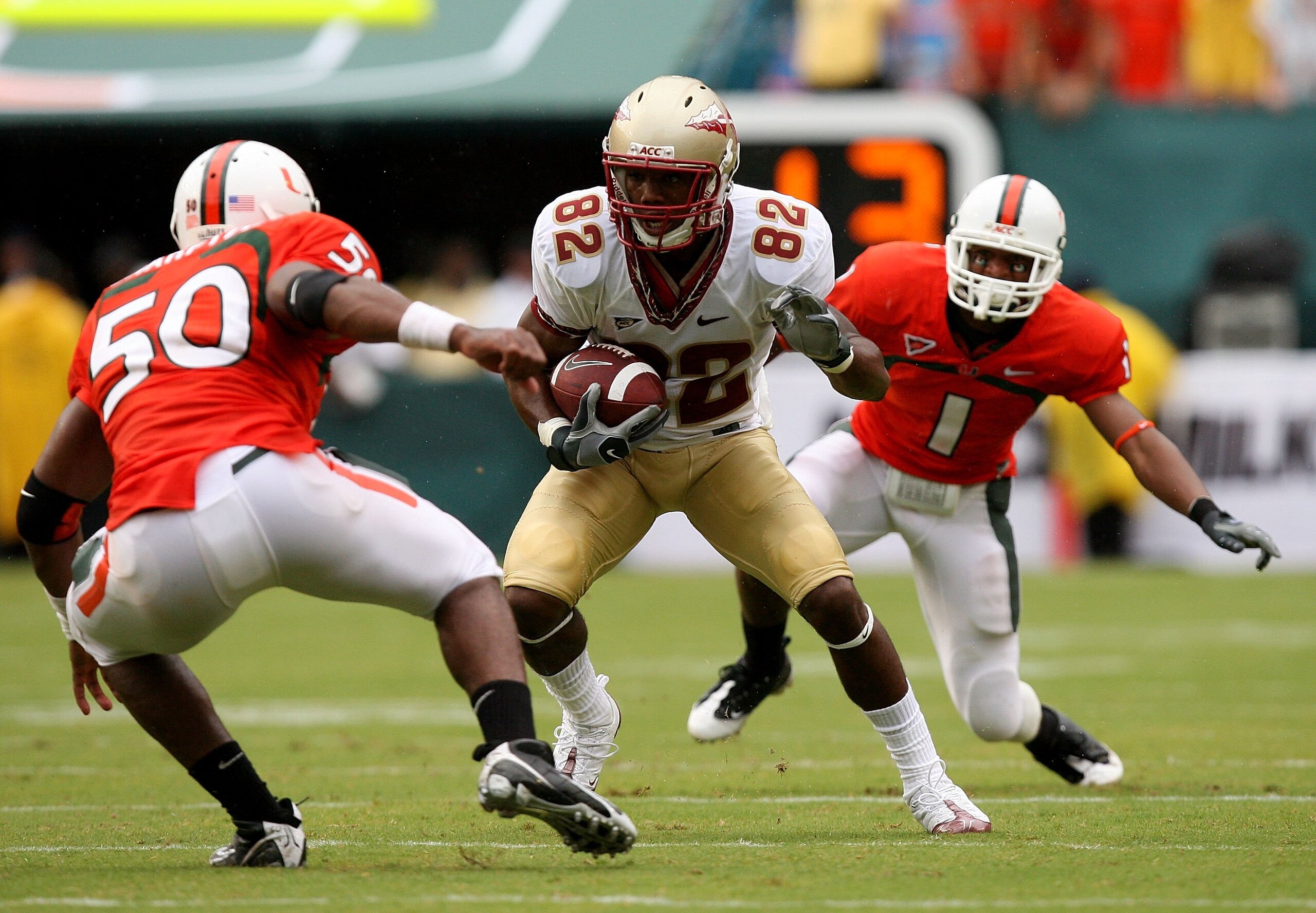 MIAMI - OCTOBER 04: Wide receiver Taiwan Easterling #82 of the Florida State Seminoles looks to avoid linebacker Darryl Sharpton #50 and defensive back Brandon Harris #1 of the Miami Hurricanes at Dolphin Stadium on October 4, 2008 in Miami, Florida. Flo MIAMI - OCTOBER 04: Wide receiver Taiwan Easterling #82 of the Florida State Seminoles looks to avoid linebacker Darryl Sharpton #50 and defensive back Brandon Harris #1 of the Miami Hurricanes at Dolphin Stadium on October 4, 2008 in Miami, Florida. Flo