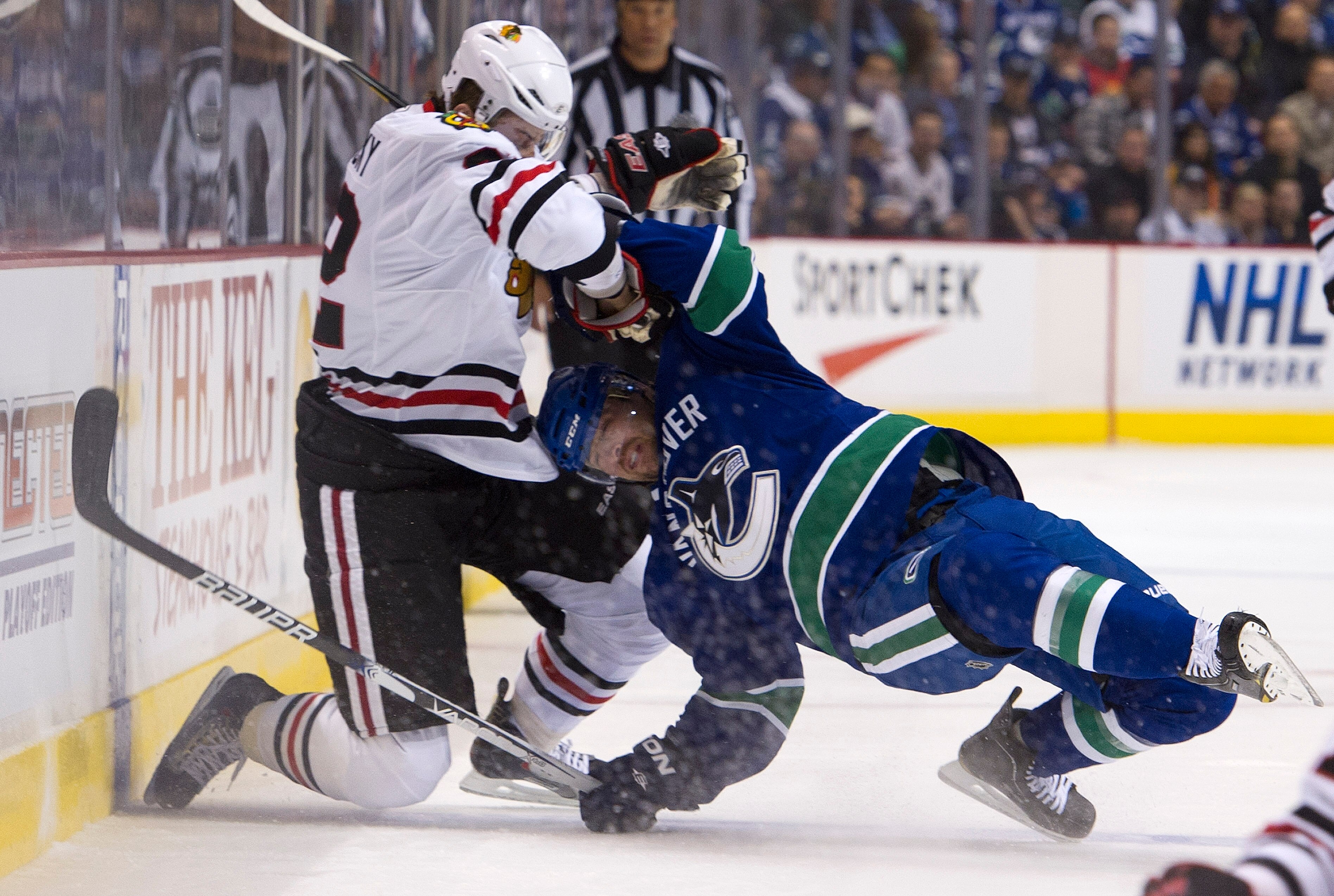 VANCOUVER, CANADA - APRIL 13: Keith Ballard #4 of the Vancouver Canucks is wrestled to the ice by Tomas Kopecky #82 of the Chicago Blackhawks during the first period in Game One of the Western Conference Quarterfinals during the 2011 NHL Stanley Cup Playo
